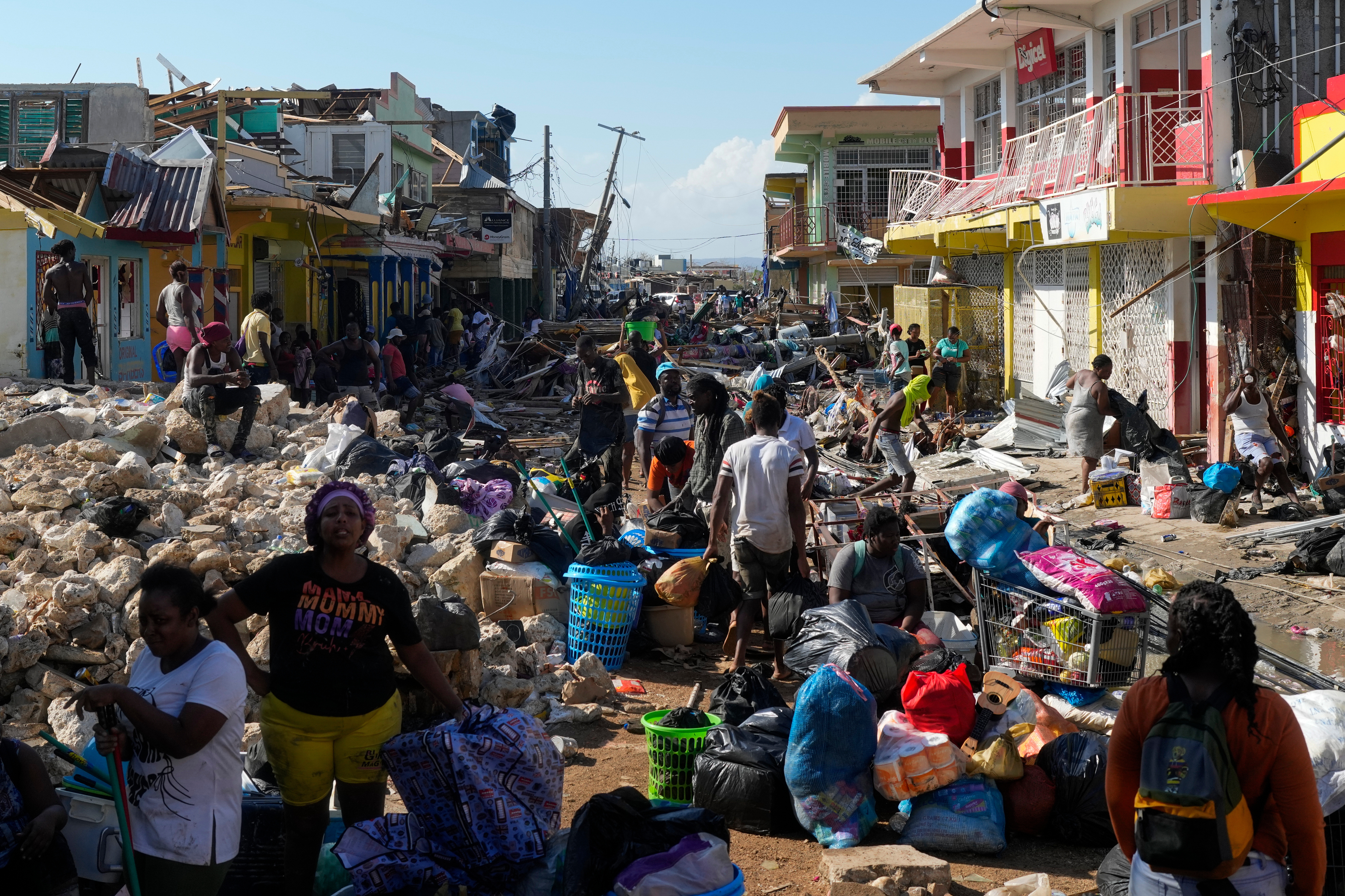 Residents gather amid debris in the aftermath of Hurricane Melissa on a street in Black River, Jamaica