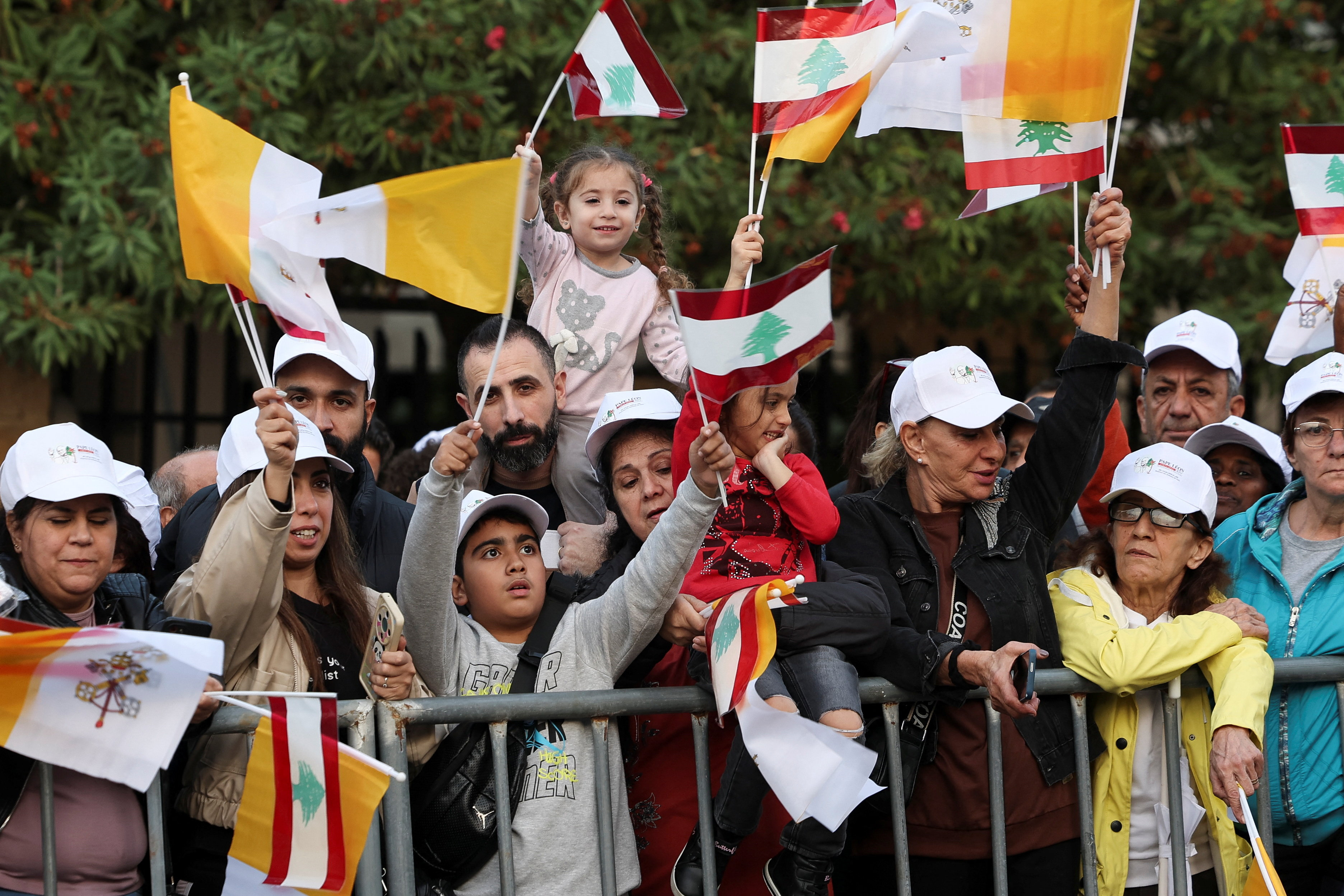 People wave Lebanese and Vatican flags on the day Pope Leo XIV arrives to Lebanon during his first apostolic journey, in Baabda, Lebanon, November 30, 2025. REUTERS/Louisa Gouliamaki