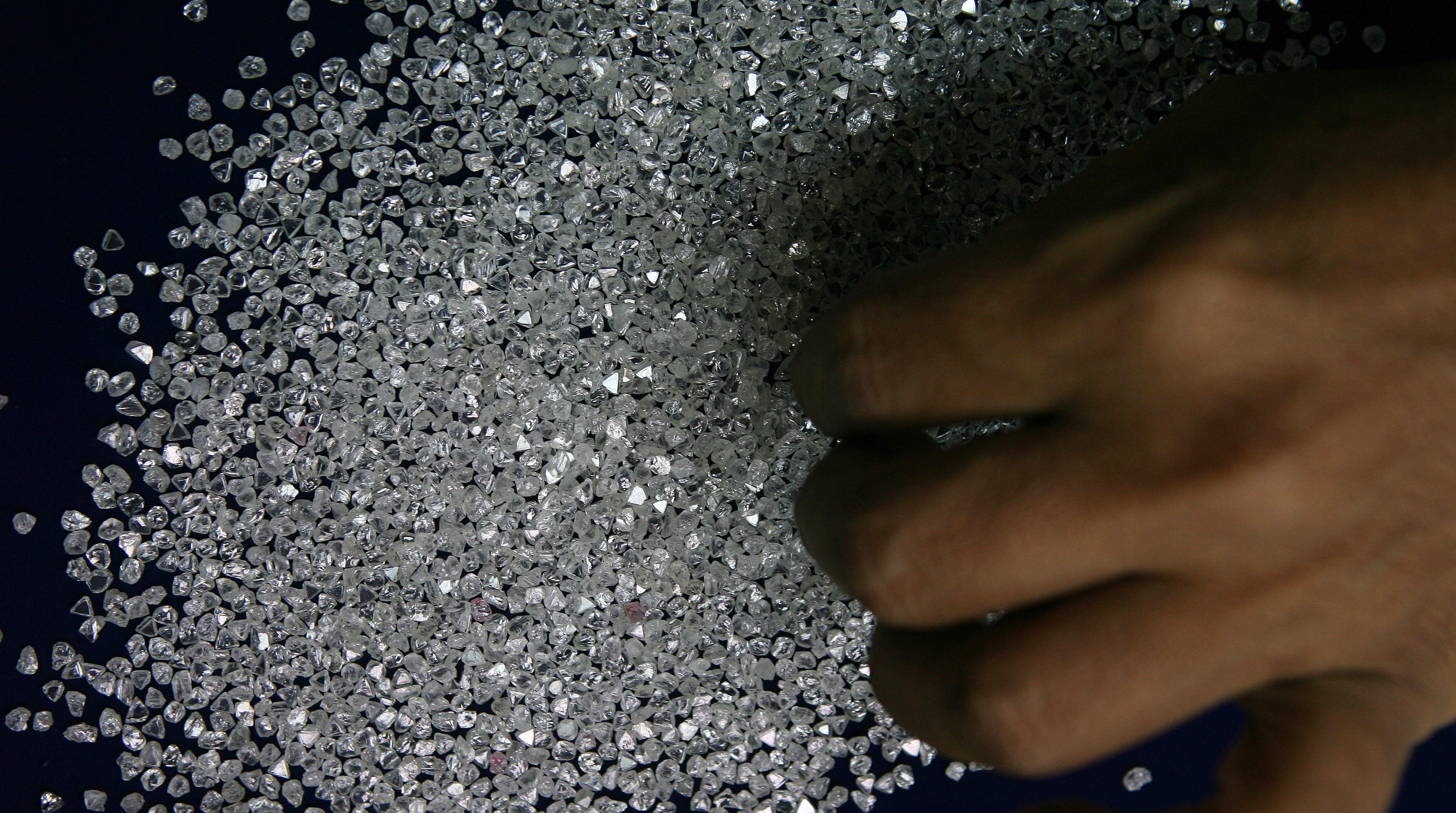 An employee sifts diamonds at a diamond cutting and polishing factory in Surat in the western Indian state of Gujarat