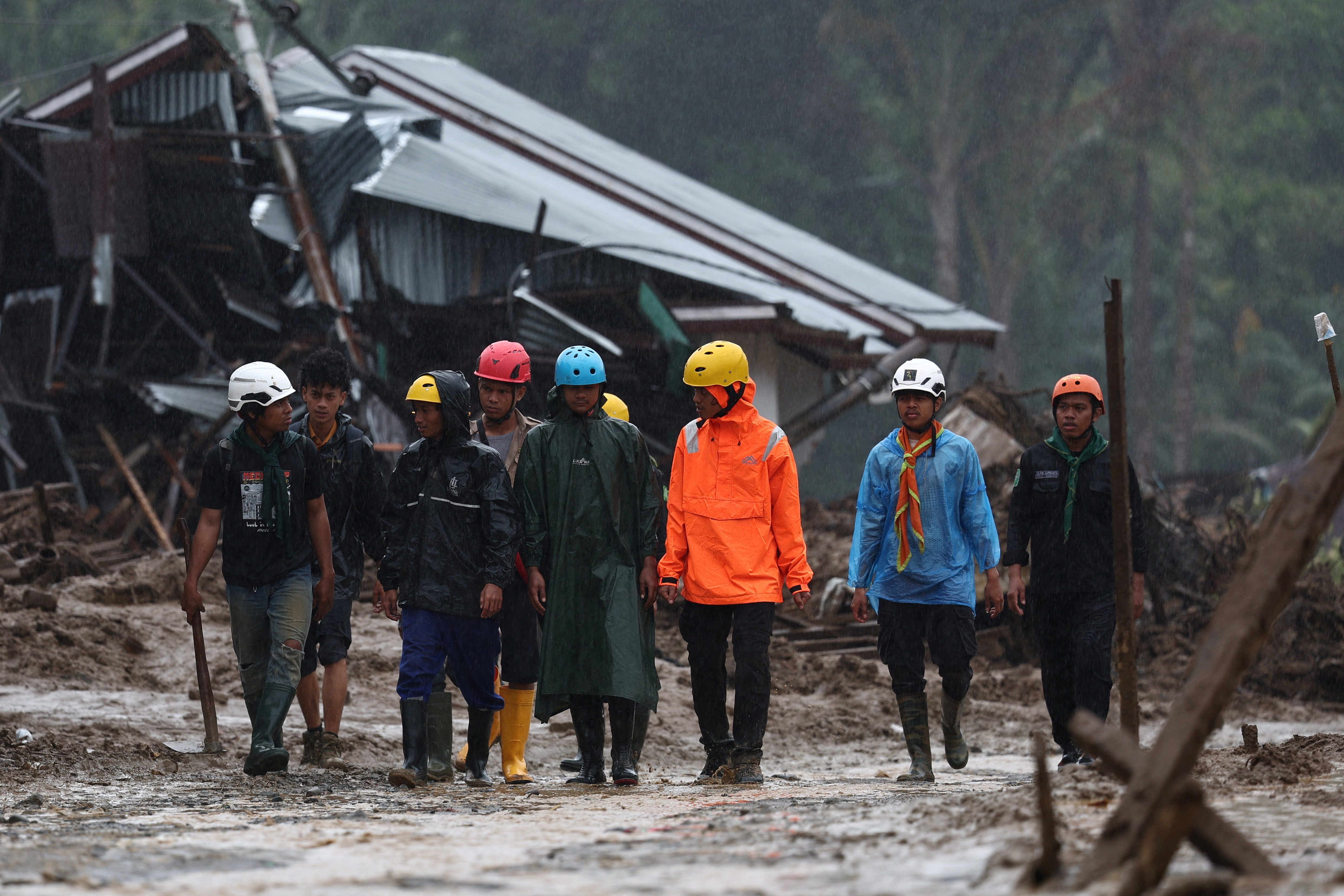 Rescue volunteers search an area hit by deadly flash floods following heavy rains in Palembayan, West Sumatra province, Indonesia