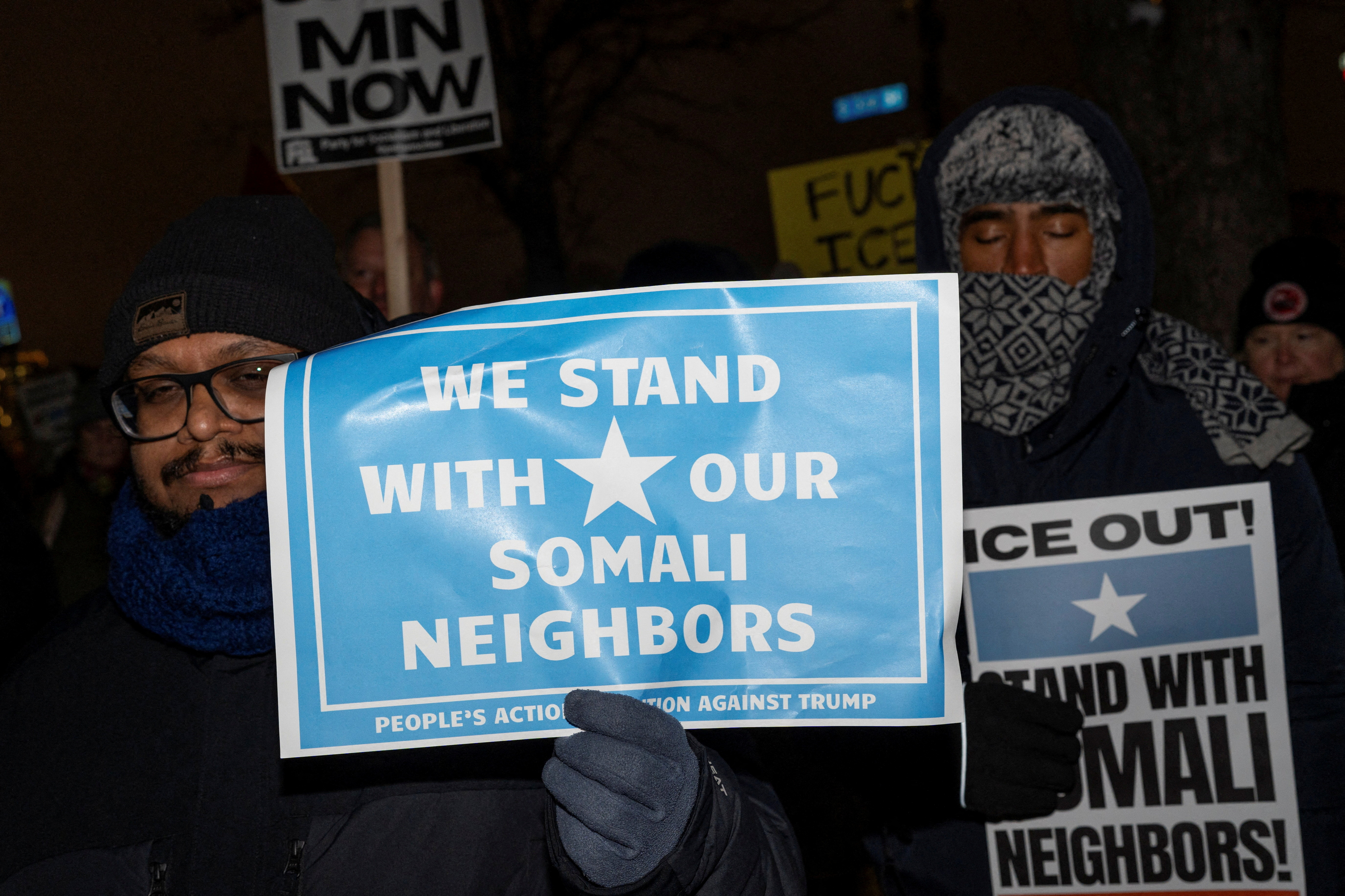 Demonstrators rally in protest with placards reading: "We stand with our Somali neighbors."