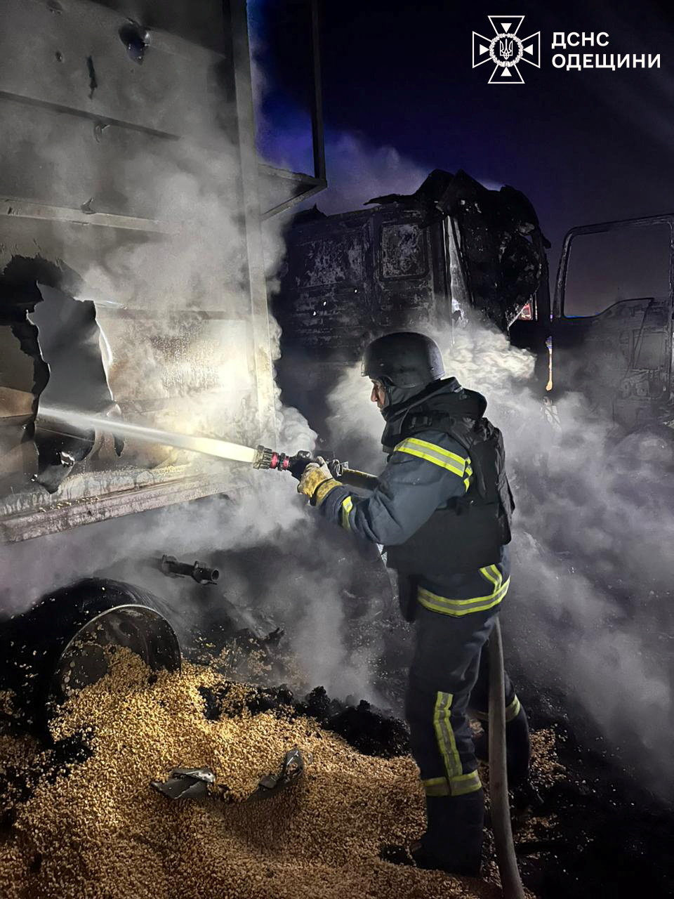 A firefighter works at the site of a missile and drone attack.