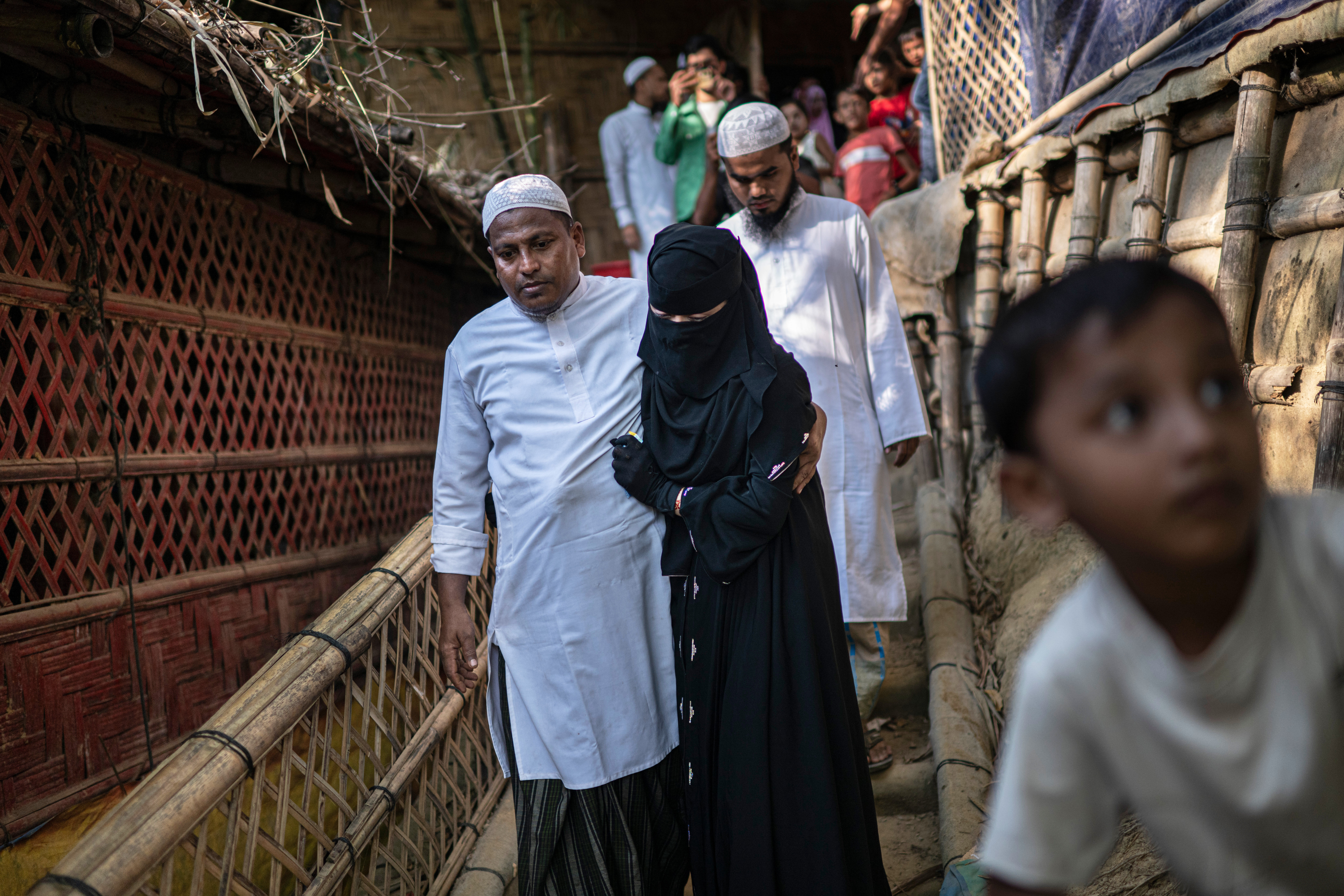 A Rohingya refugee bride is escorted by her father to her husband's house.
