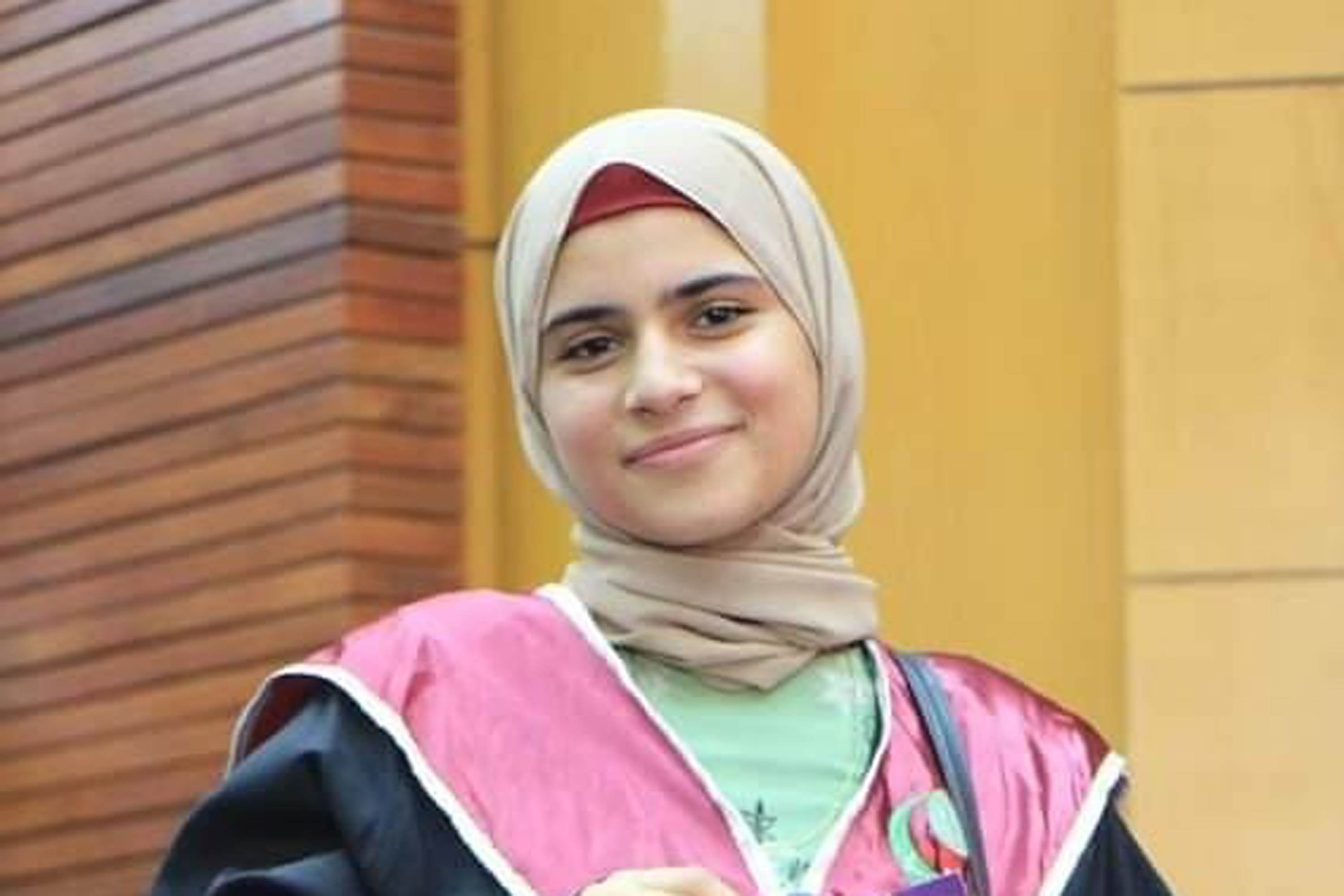A photo of a young woman in graduation gown