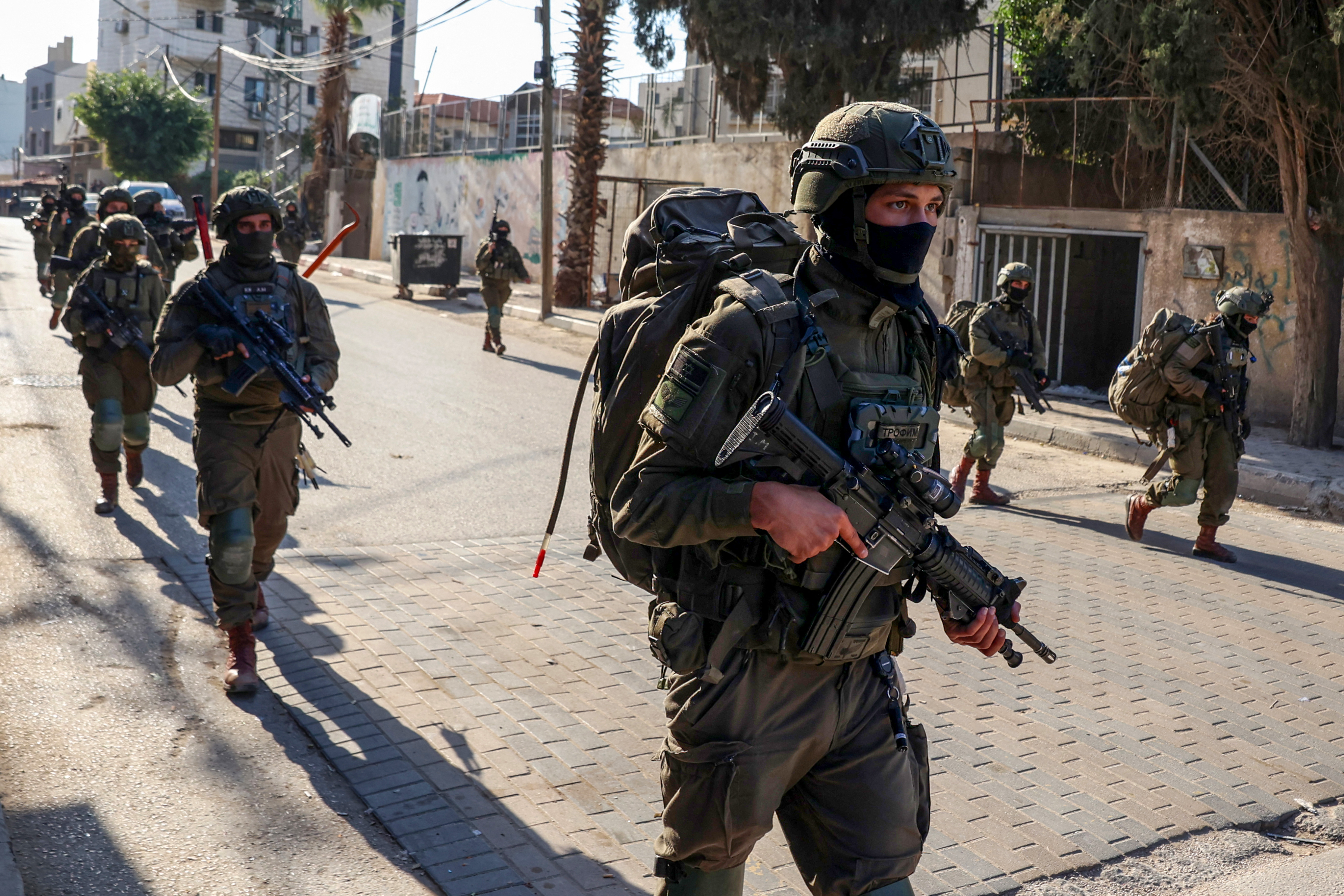 Israeli soldiers walk during a military operation in the town of Qalqiya, in the occupied West Bank on December 4, 2025.