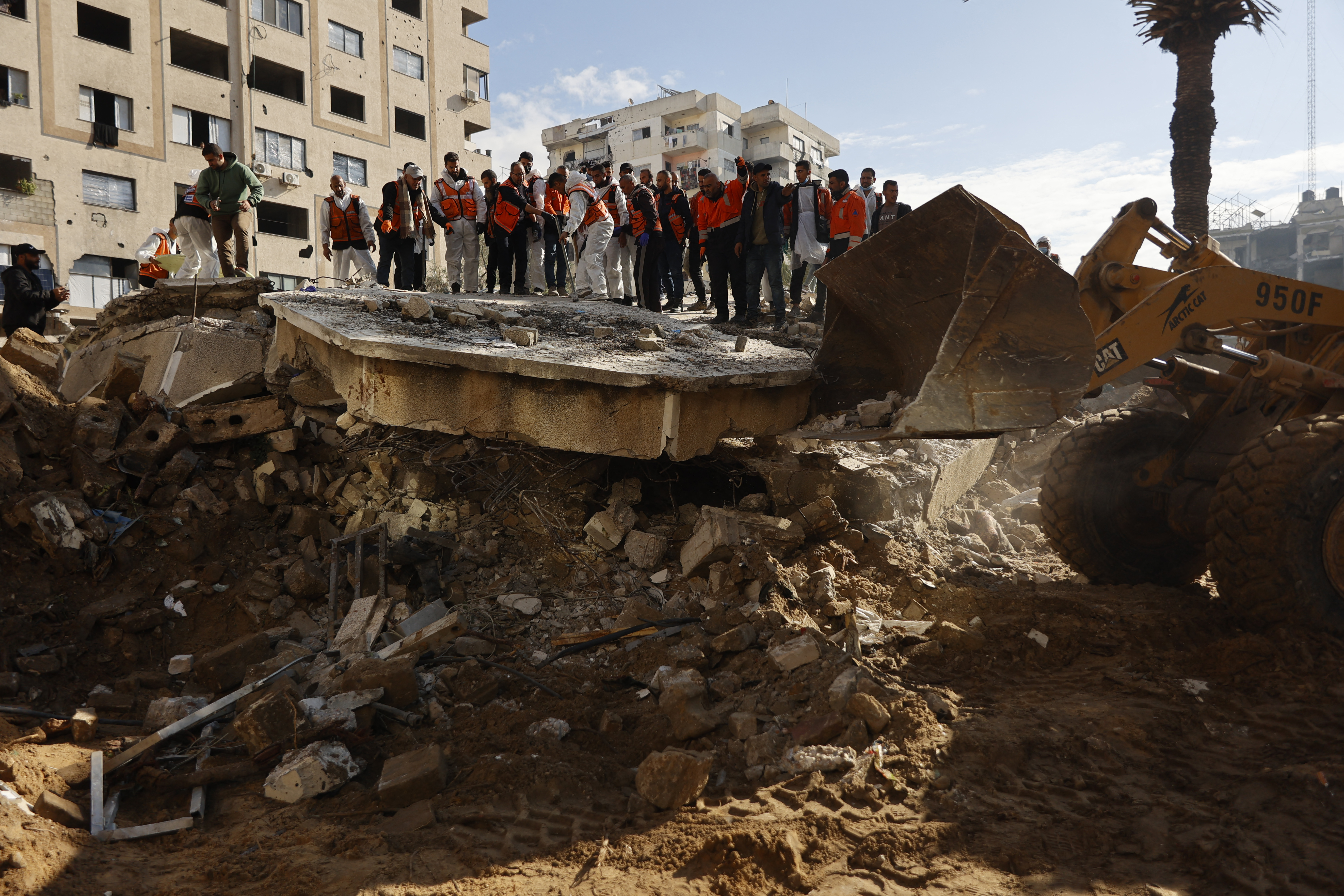 Members of the Palestinian civil defence search for the bodies of the Salem family in the rubble of a building destroyed in 2023 in the Rimal neighbourhood of Gaza City on December 15, 2025.