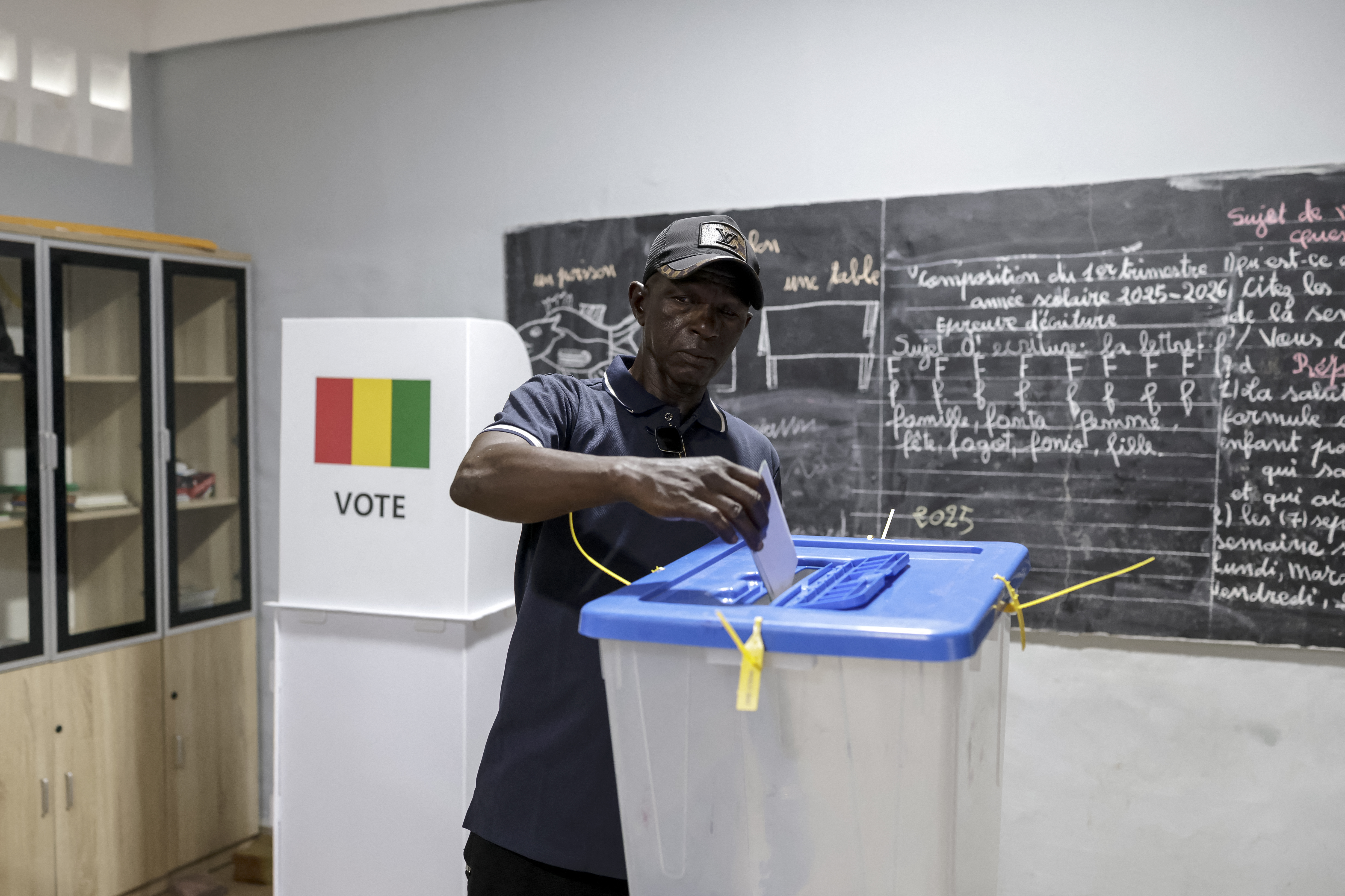 A voter casts his ballot at a polling station in Conakry on December 28, 2025 during Guinea's presidential election