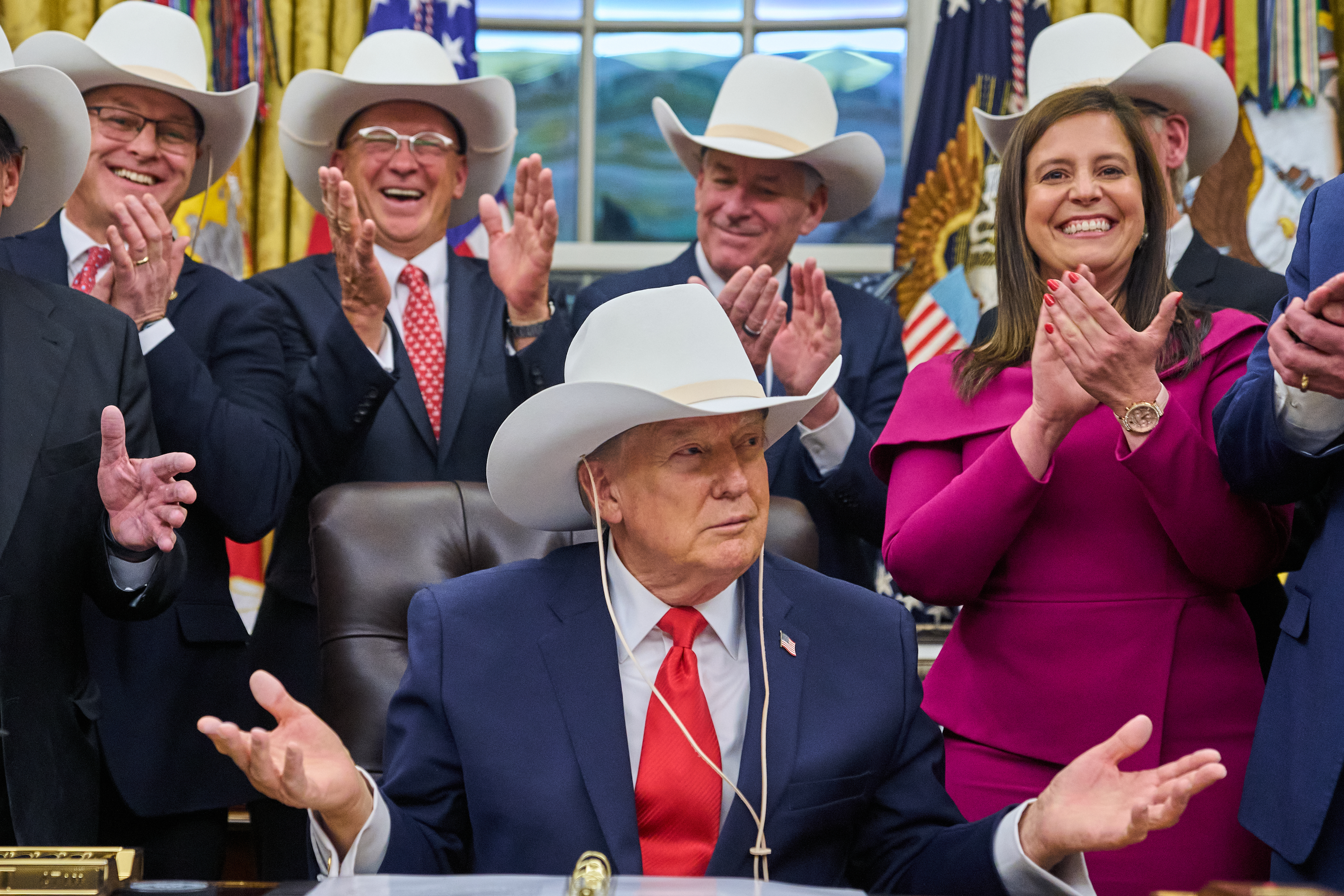 President Donald Trump tries on a hat