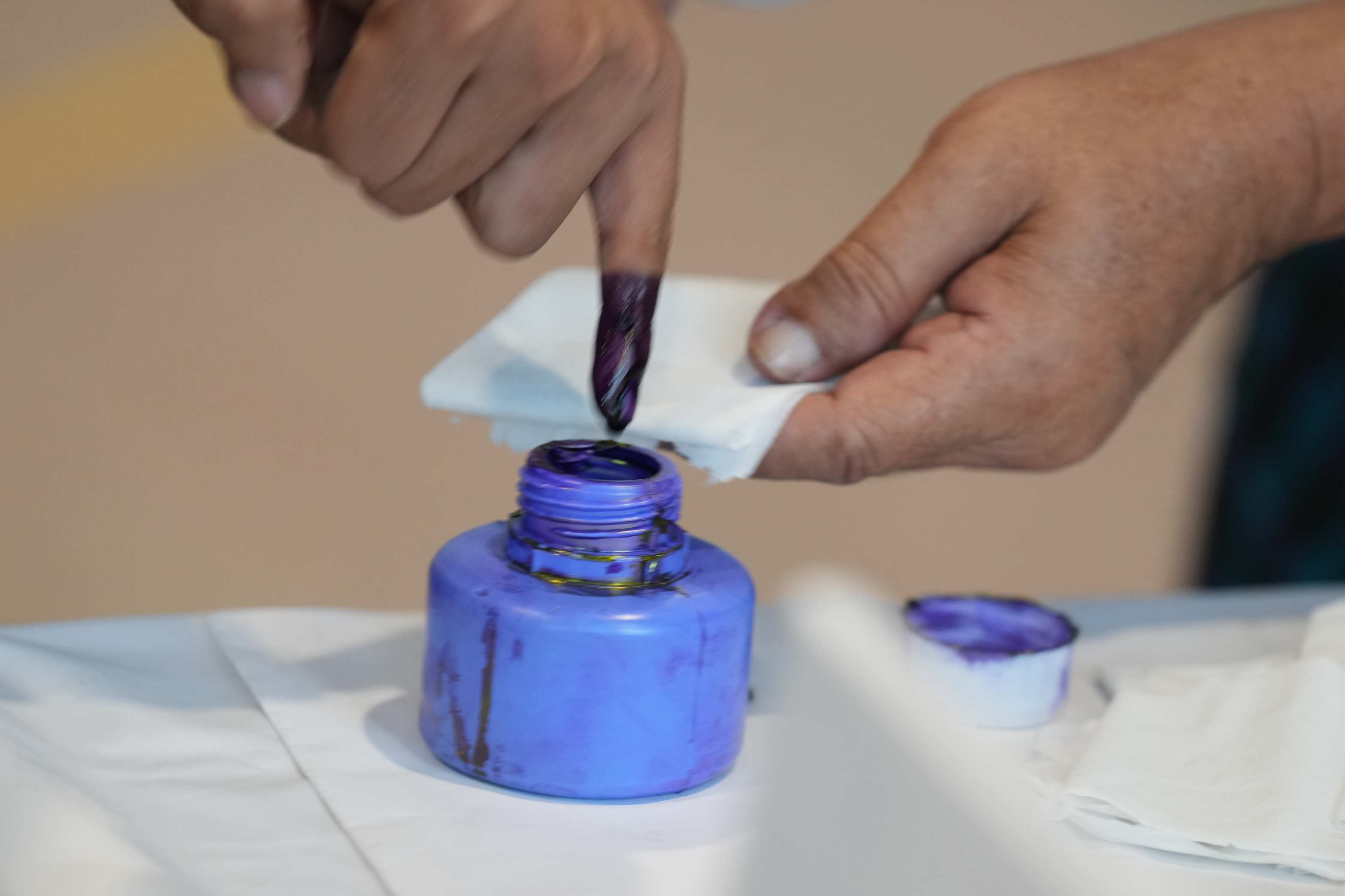 A voter dips his finger in an ink bottle after casting a ballot at a polling station Sunday, Dec. 28, 2025, in Yangon, Myanmar. (AP Photo/Thein Zaw)