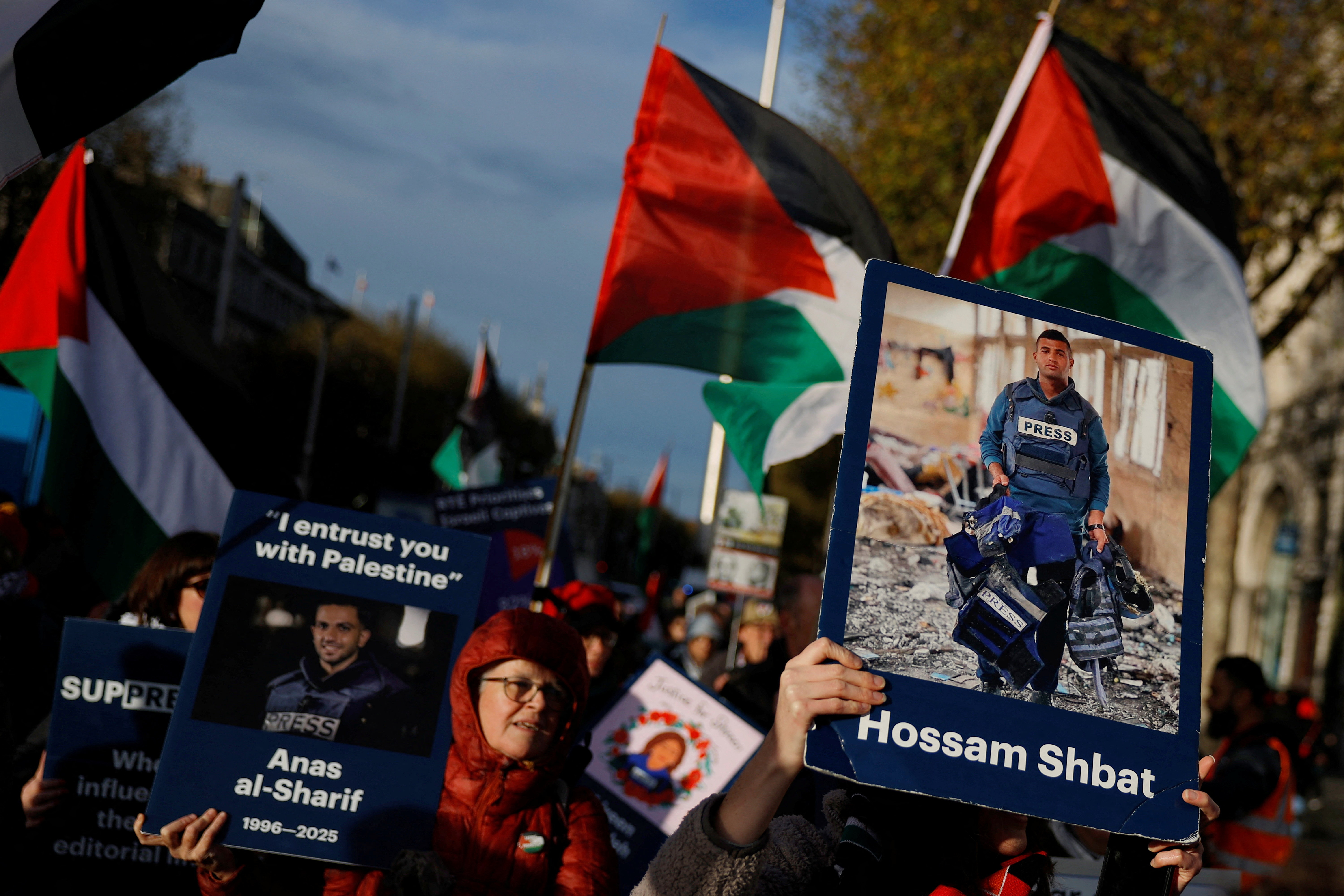 Demonstrators hold placards of slain journalists from Gaza Hossam Shbat and Anas al-Sharif, in support of Palestinians during a march on the International Day of Solidarity, in Dublin, Ireland