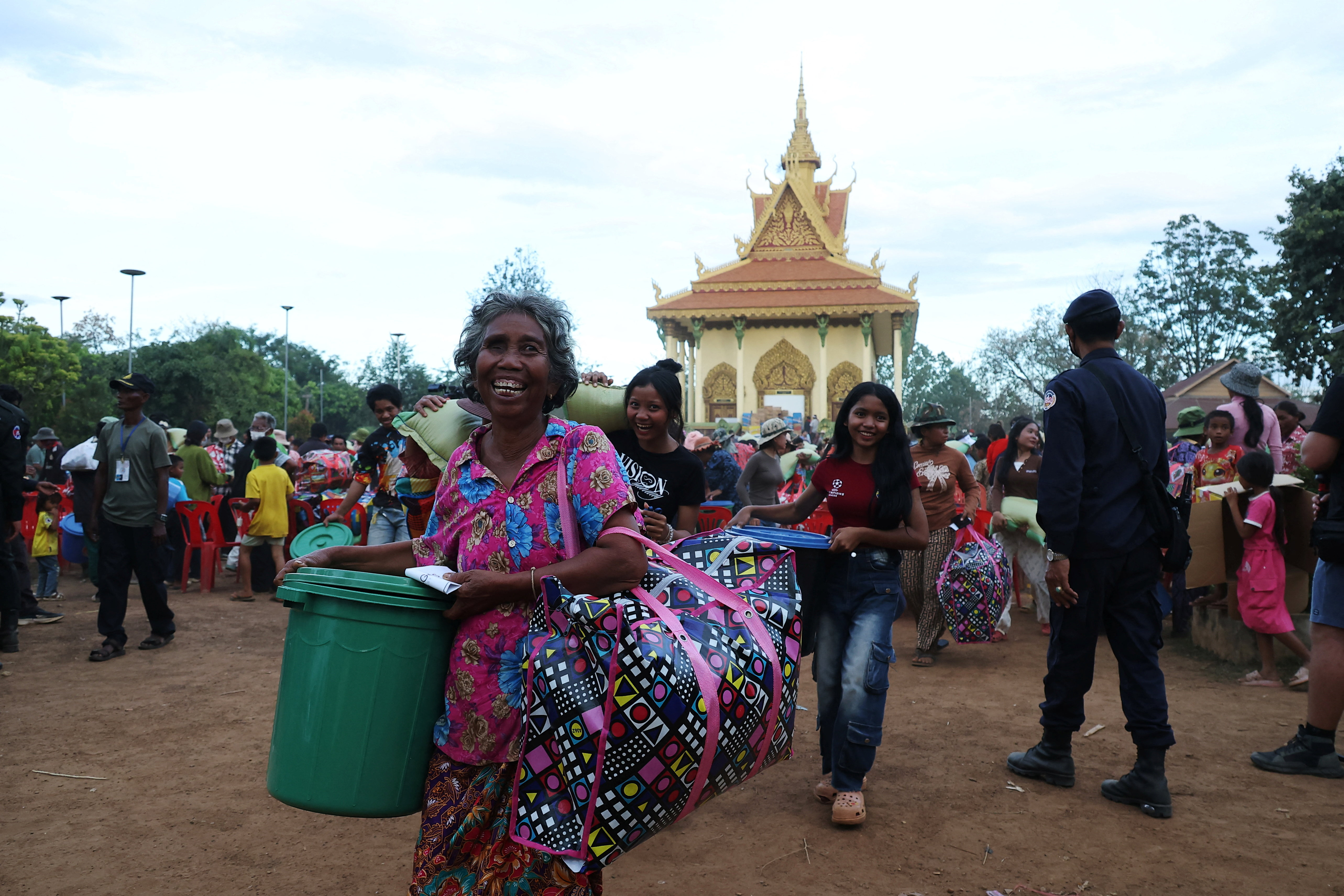 People carry supplies at Batthkav refugee camp, amid clashes between Thailand and Cambodia along a disputed border area, in Chong Kal, Oddar Meanchey Province, Cambodia, December 12, 2025. REUTERS/Kim Hong-Ji