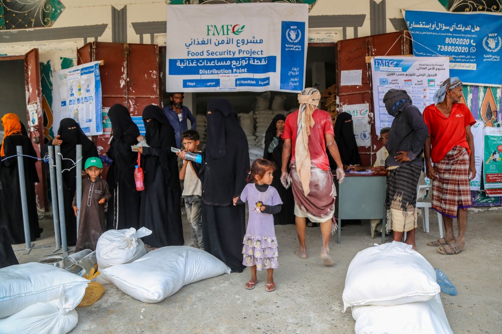 Displaced Yemenis line up to receive bags of food and supplies to meet their basic needs in the western province of Hodeida on May 4, 2025. (Photo by Khaled ZIAD / AFP)