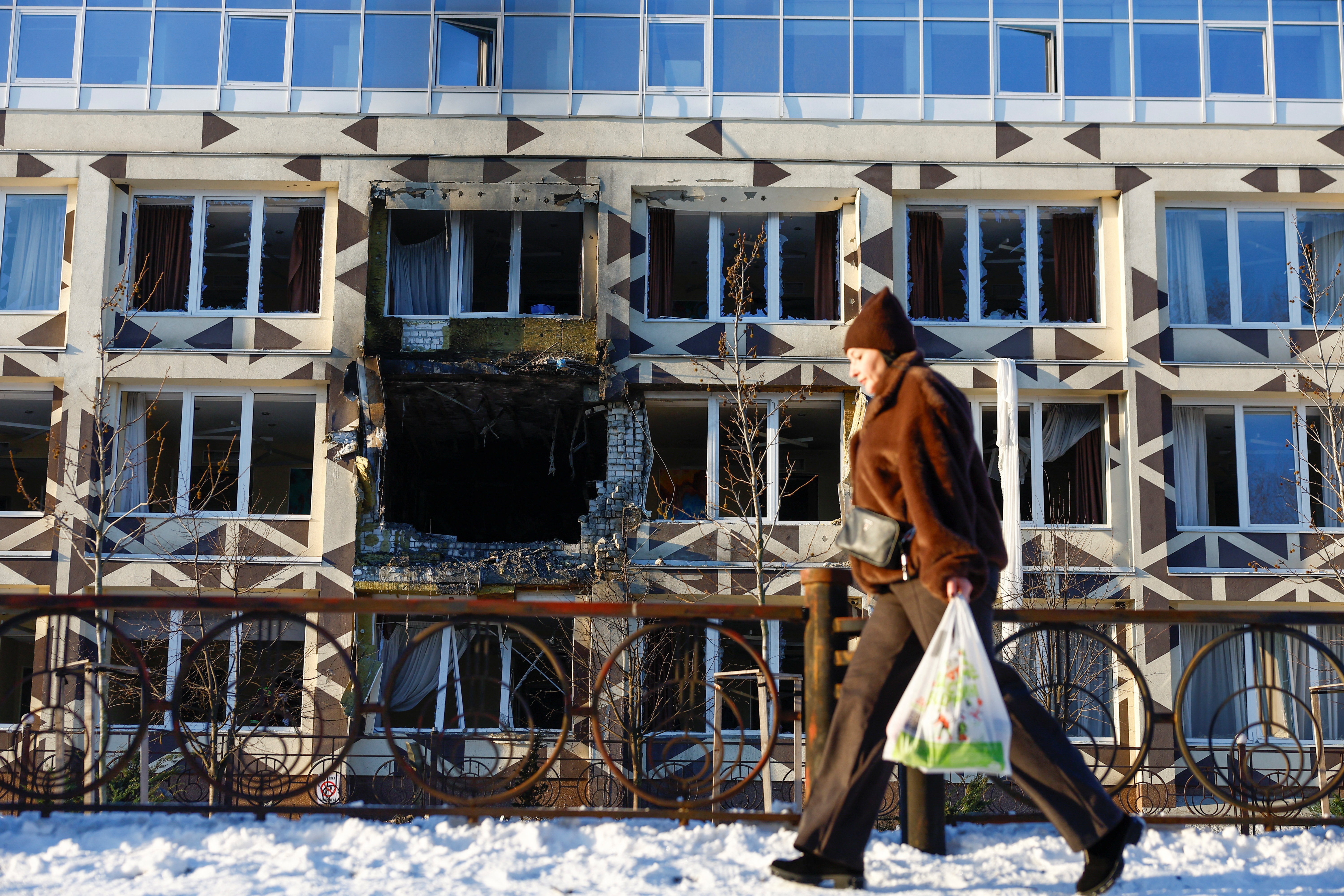 A resident walks past a building of a private hospital hit by Russian drone strikes, amid Russia's attack on Ukraine, in Kyiv, Ukraine January 5, 2026. REUTERS/Valentyn Ogirenko TPX IMAGES OF THE DAY