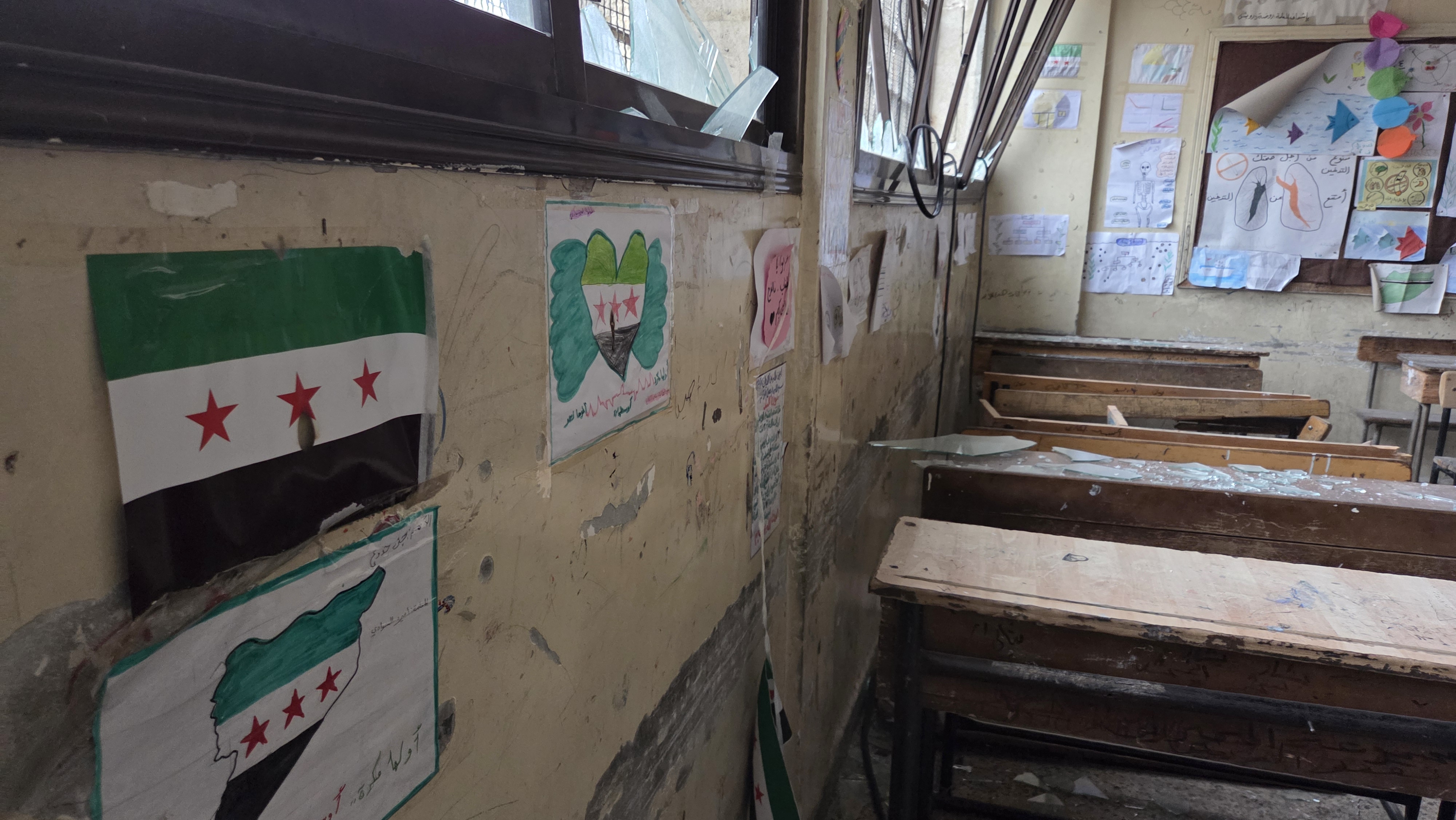 Syrian flag visible on wall of classroom