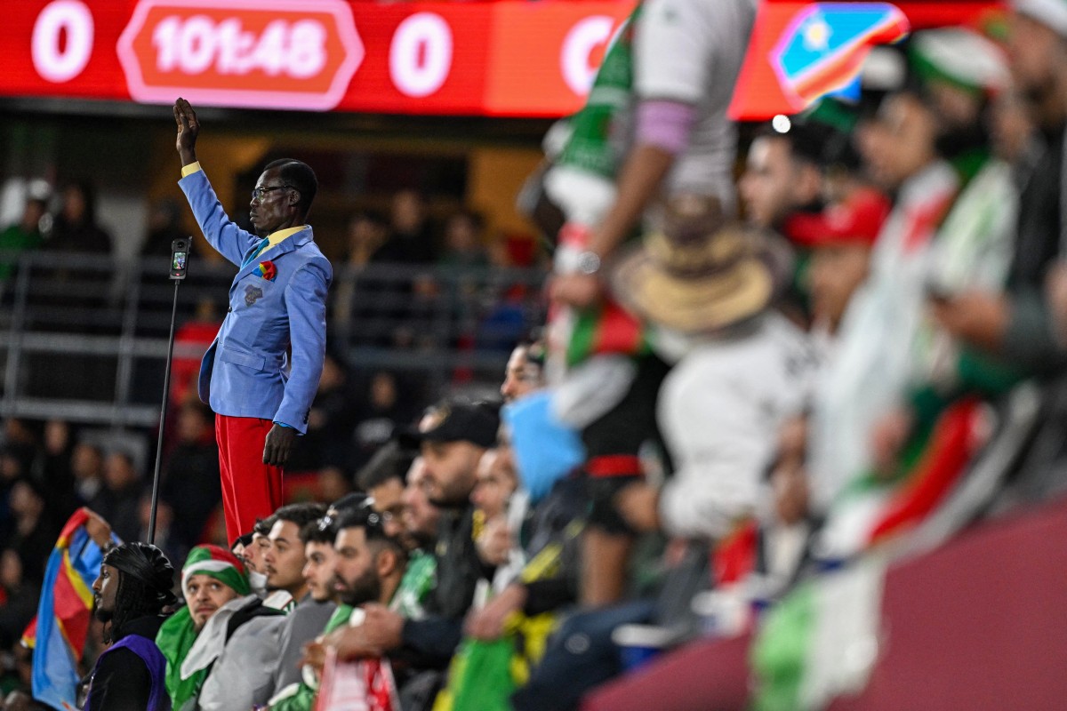 Democratic Republic of Congo's supporter Michel Kuka Mboladinga, pays tribute to Democratic Republic of Congo's late prime minister Patrice Lumumba, by remaining motionless before the Africa Cup of Nations (CAN) round of 16 football match between Algeria and Democratic Republic of Congo at the Prince Moulay El Hassan Stadium in Rabat on January 6, 2026. (Photo by Gabriel BOUYS / AFP)