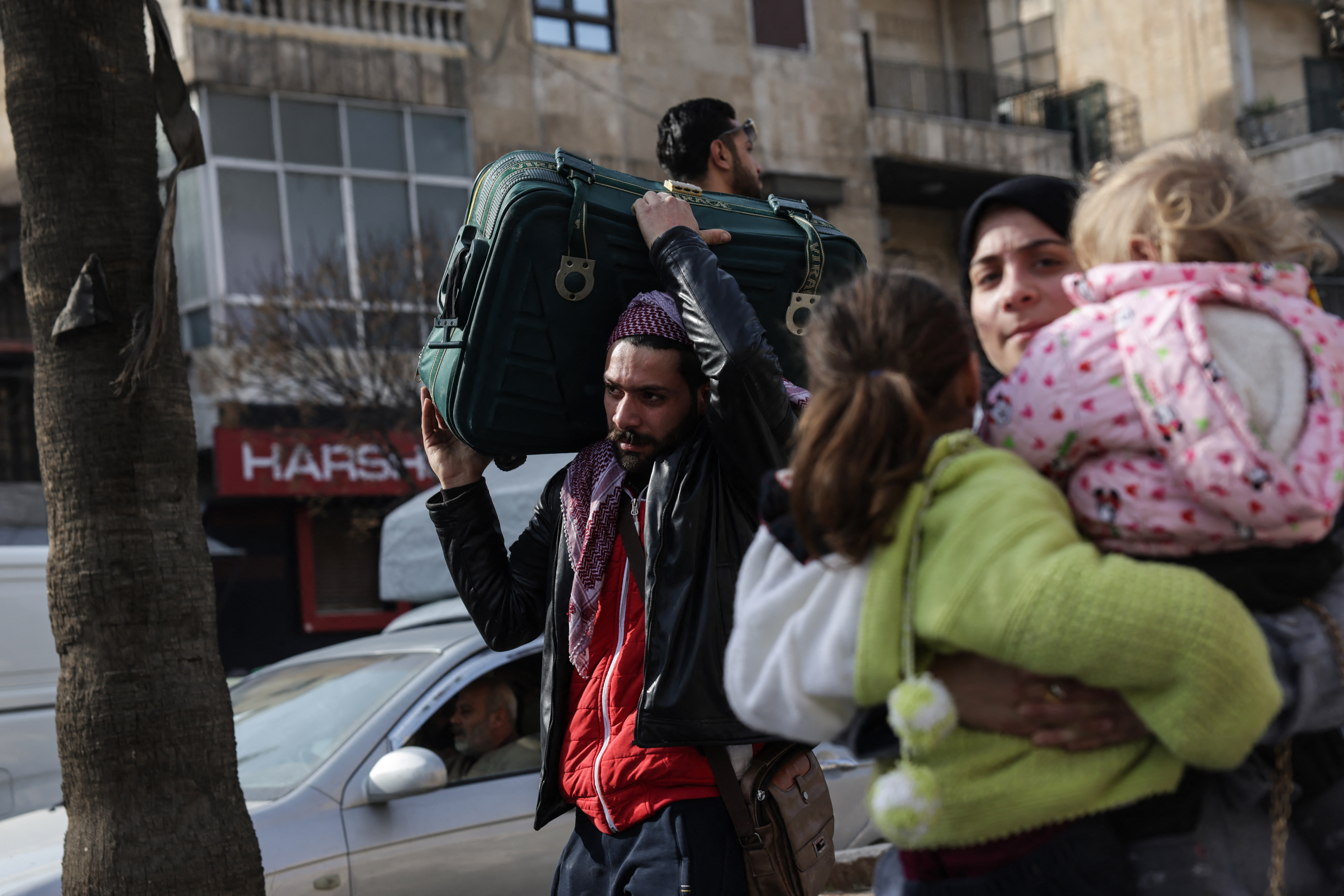 Residents carry their belongings as they flee Aleppo's Ashrafieh Kurdish neighbourhood on January 7, 2026. Civilians were fleeing Kurdish neighbourhoods of Aleppo on January 7 after the Syrian army declared them "closed military zones", amid ongoing fighting with Kurdish-led forces in the northern city. The deadly clashes, which started on January 6, are the worst between the two sides, who have so far failed to implement a March deal to merge the Kurds' semi-autonomous administration and military into Syria's new Islamist government. (Photo by Bakr ALkasem / AFP)