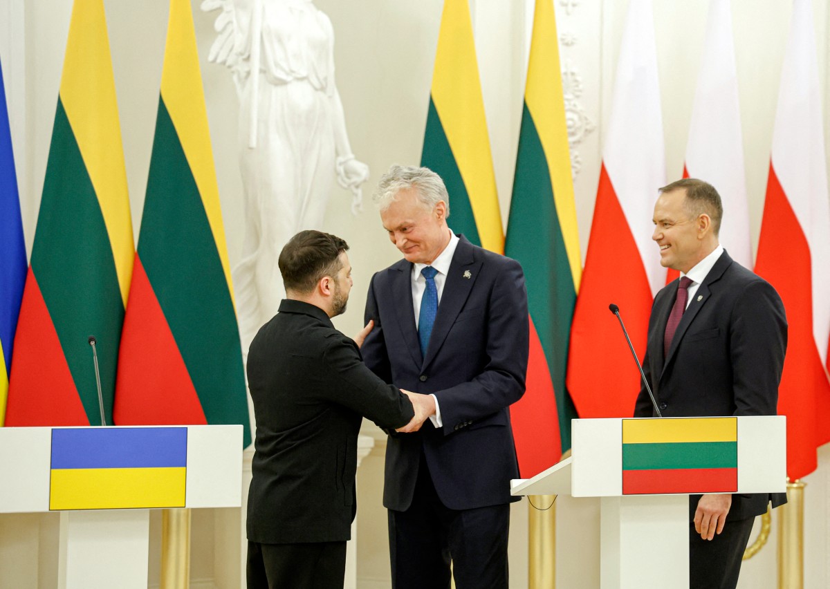 Ukraine's President Volodymyr Zelensky, Lithuania's President Gitanas Nauseda and Poland's President Karol Nawrocki react at the end of a joint press conference after attending commemorations of the 1863 uprising, in Vilnius on January 25, 2026. (Photo by Petras Malukas / AFP)