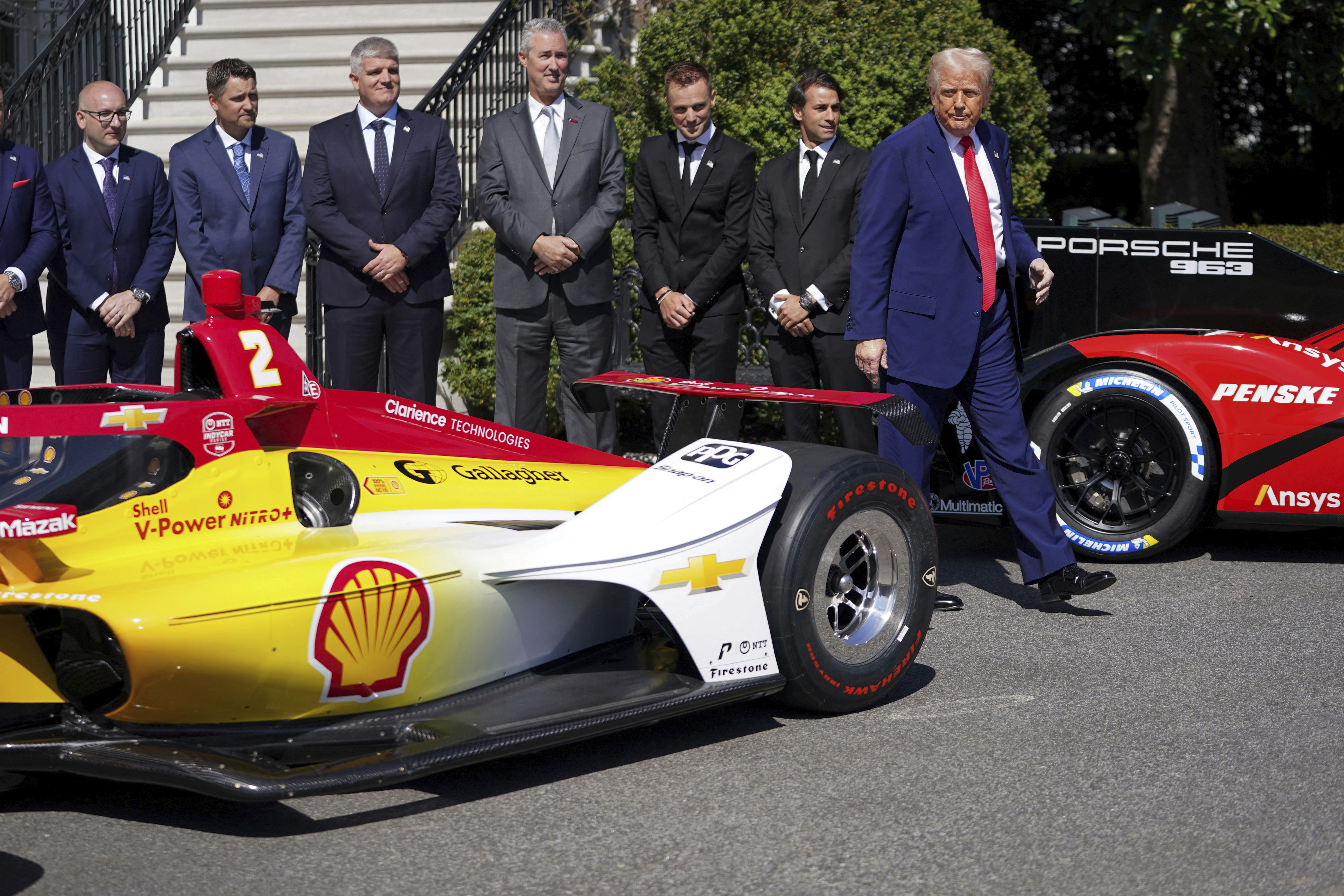 Trump walks past a racing car