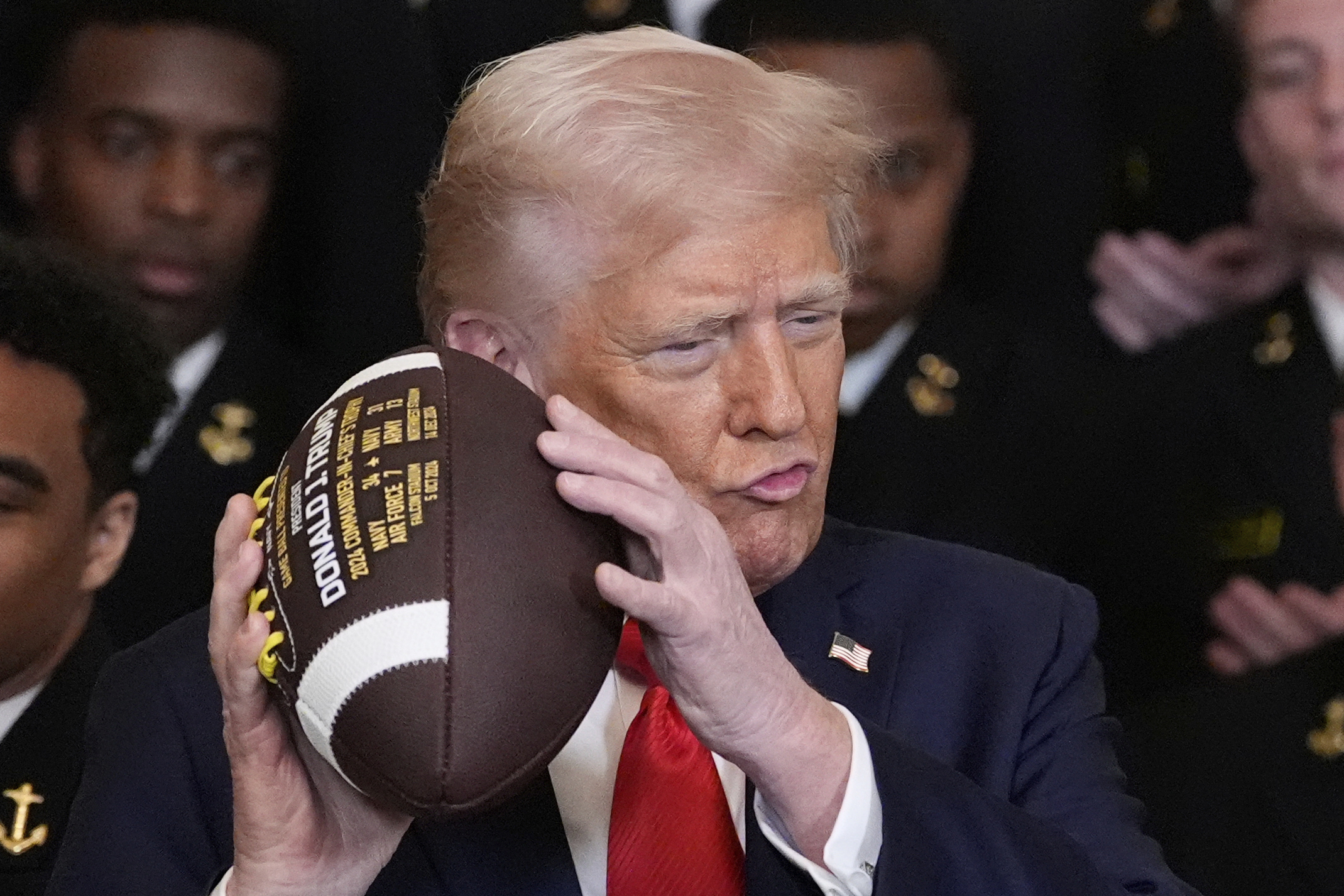 Trump poses with a football