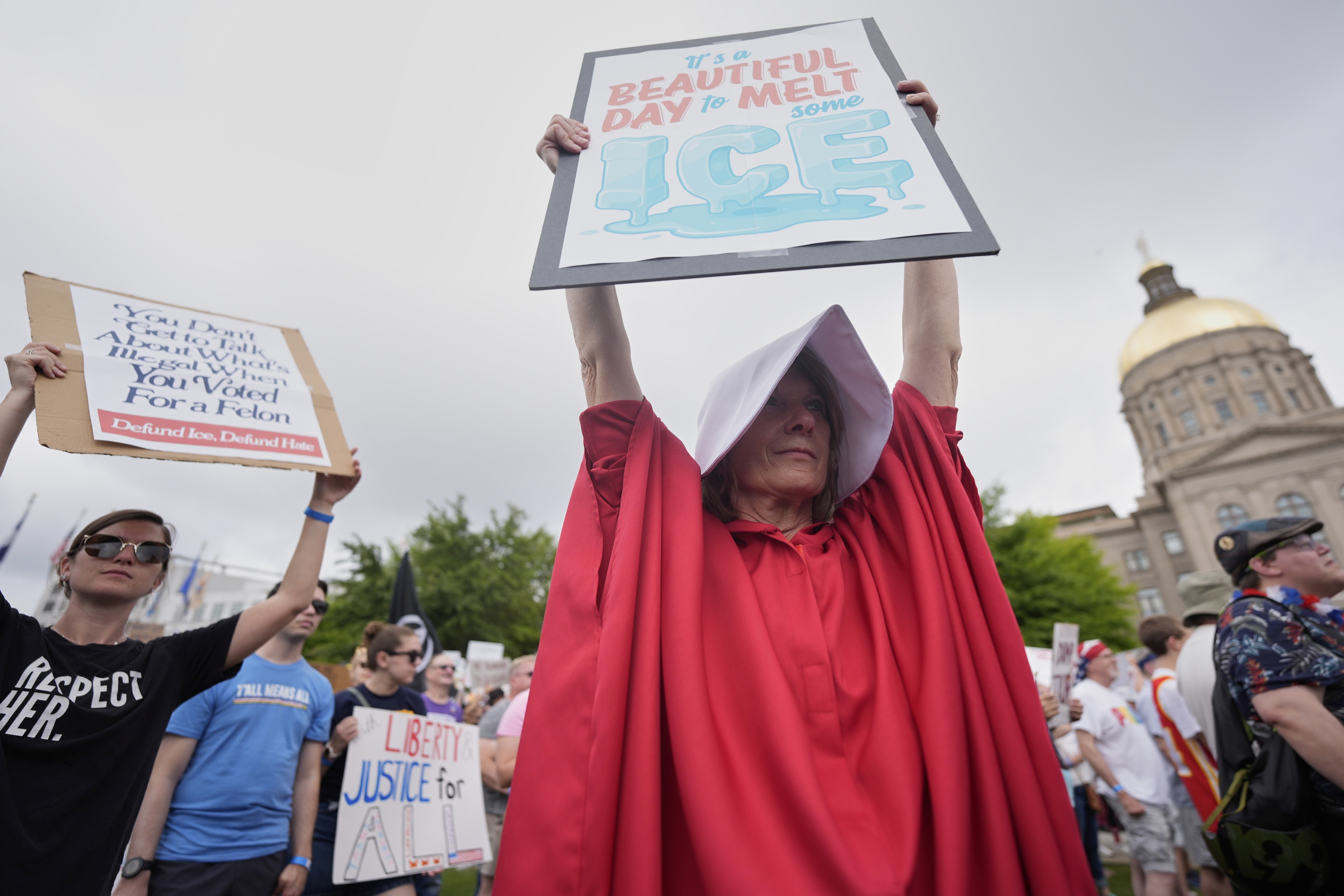 Protesters hold up anti-ICE signs at a protest in Atlanta