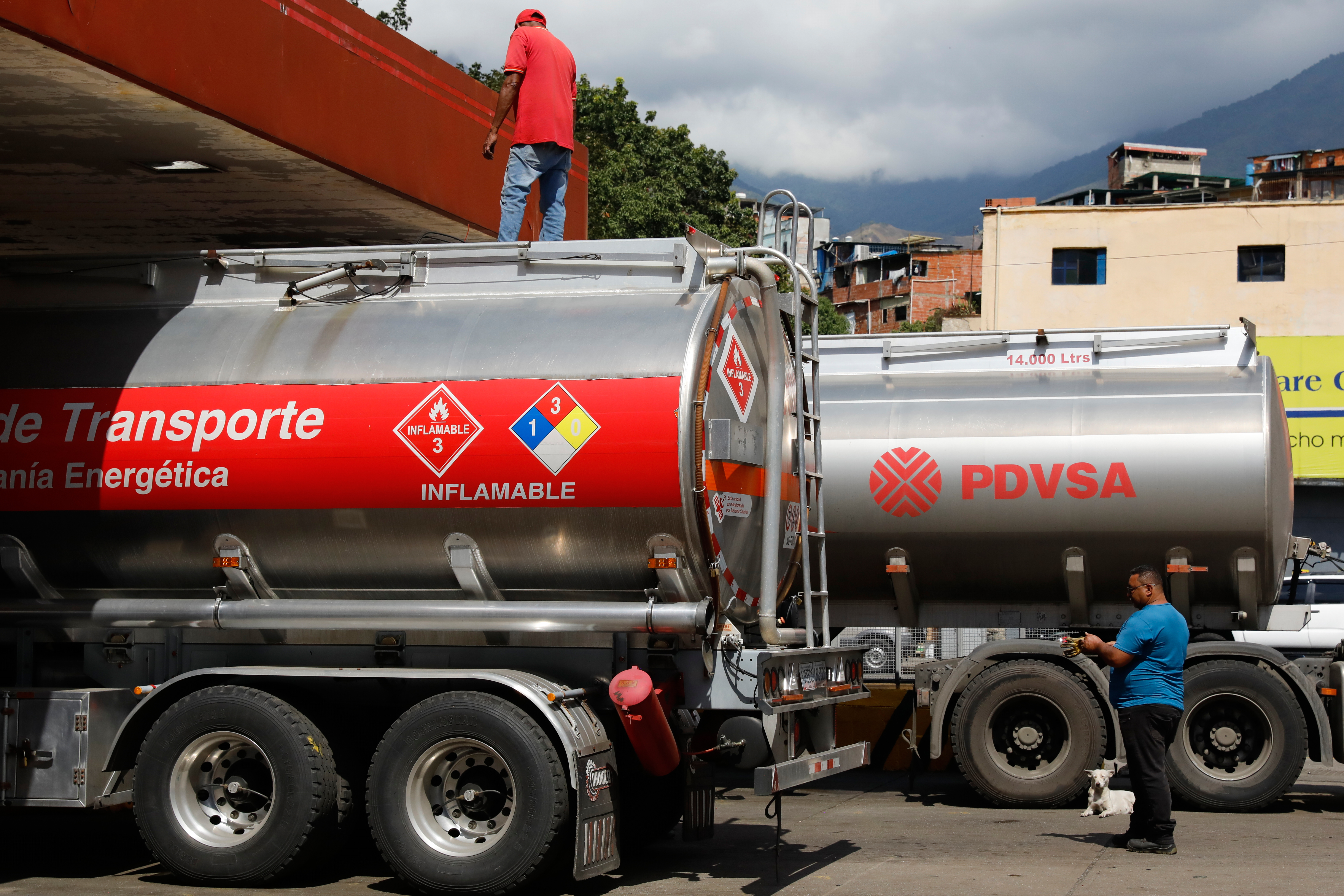Fuel tanker trucks unload fuel at a gas station in Caracas, Venezuela