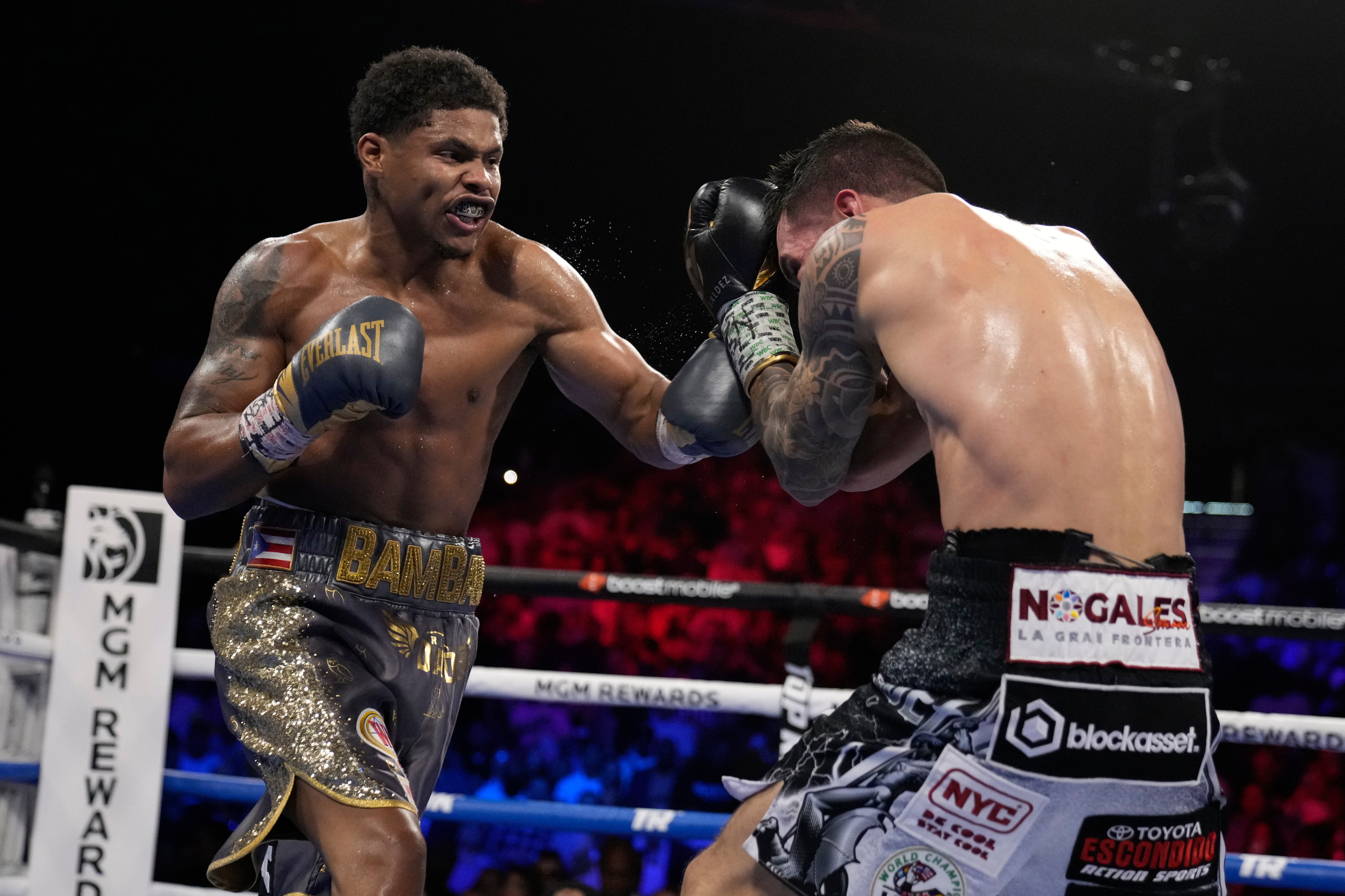 Shakur Stevenson, left, throws a punch at Oscar Valdez during a boxing match.