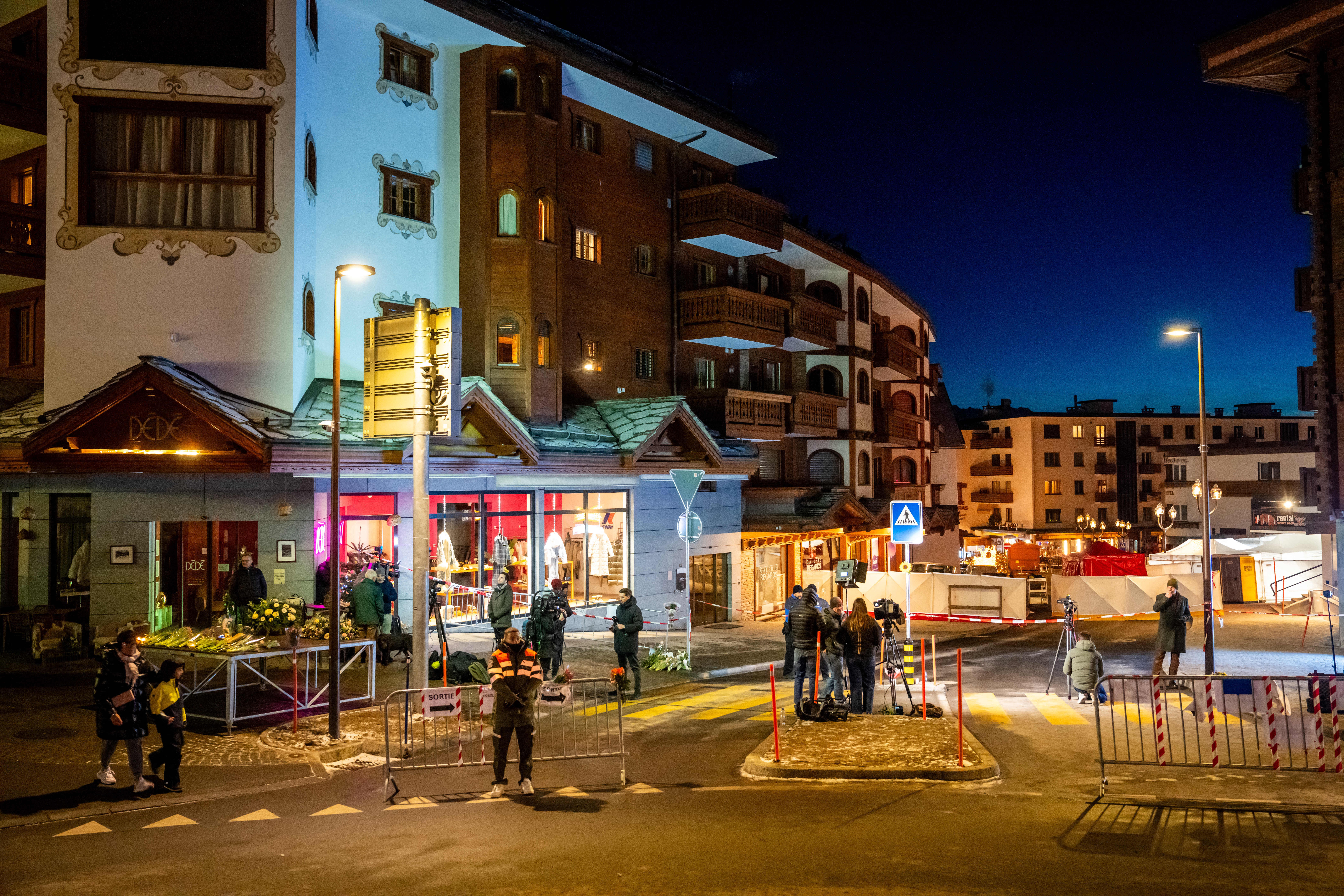 Journalists gather in front of the street where a fire ripped through a crowded bar during New Year's Eve celebrations in the Alpine ski resort town of Crans-Montana on January 1, 2026.