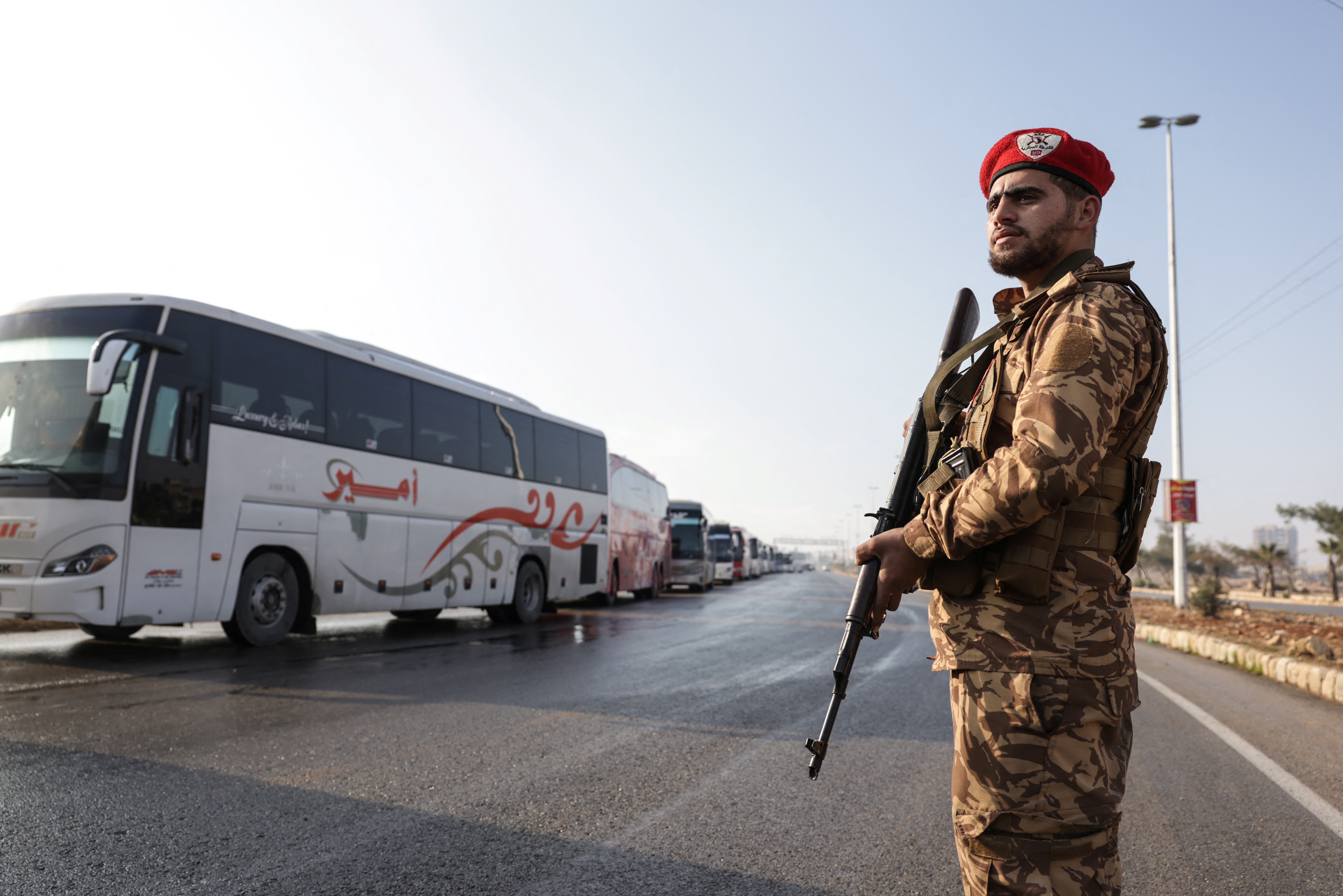 Buses stand by close to the Lairamoun roundabout as they wait to enter the Sheikh Maqsud neighbourhood to evacuate US-backed Kurdish-led Syrian Democratic Forces (SDF) fighters from two districts of the city of Aleppo, northern Syria, on January 9, 2026.