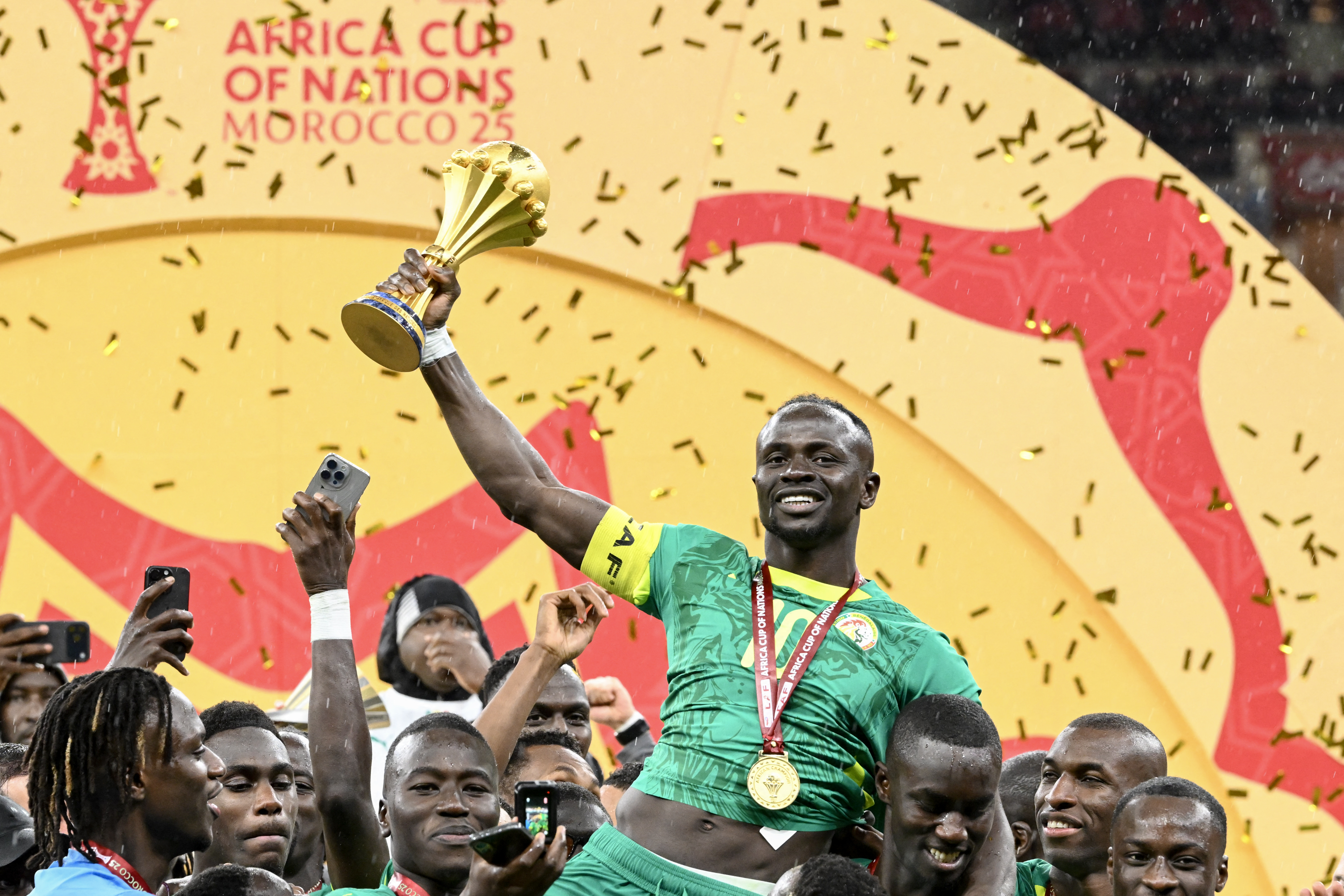Senegal's forward #10 Sadio Mane holds up the trophy as he celebrates with his teammates after winning the Africa Cup of Nations (CAN) final football match between Senegal and Morocco at the Prince Moulay Abdellah Stadium in Rabat on January 18, 2026.