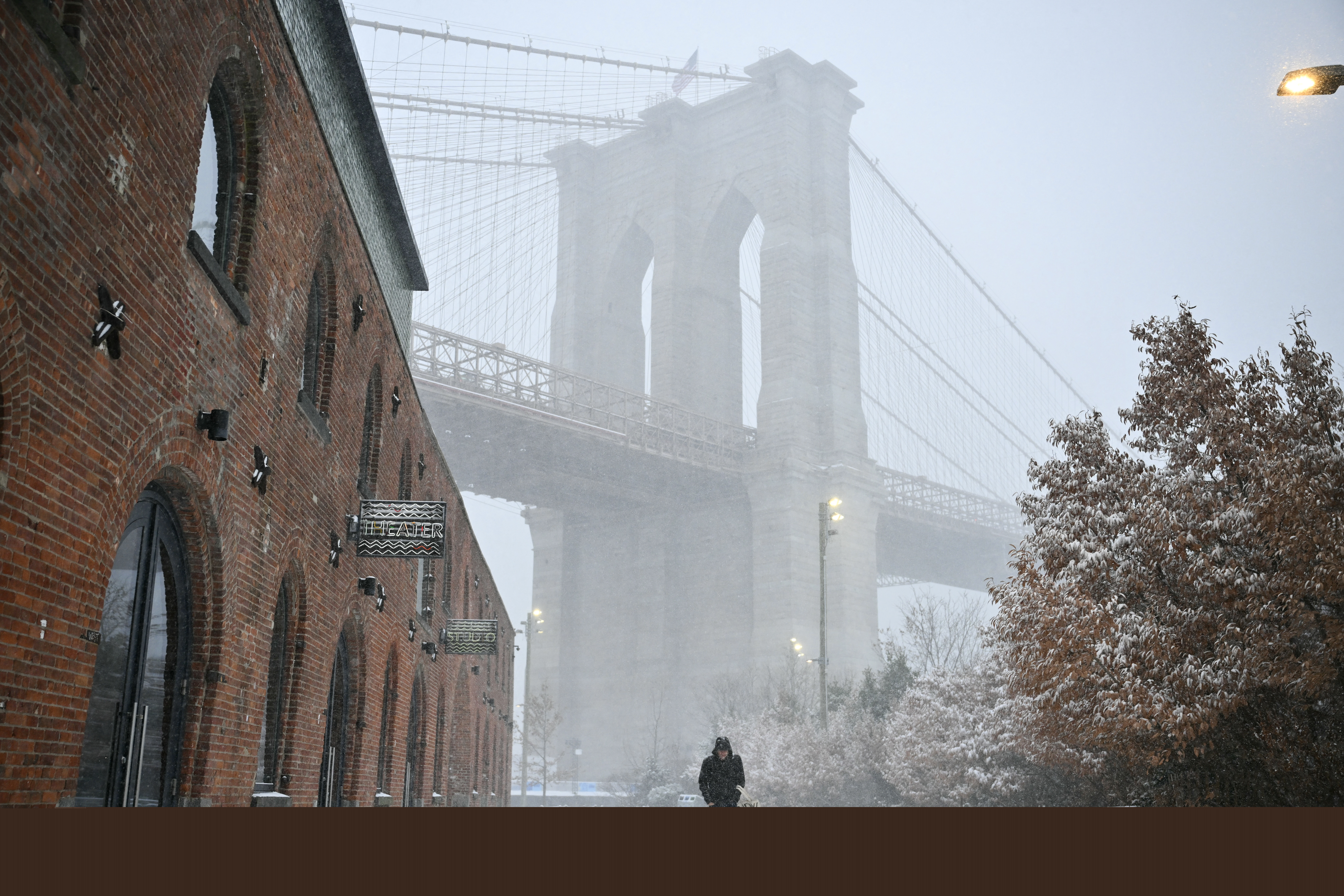 A person walks in the snow near the Brooklyn Bridge in New York City on January 25, 2026.