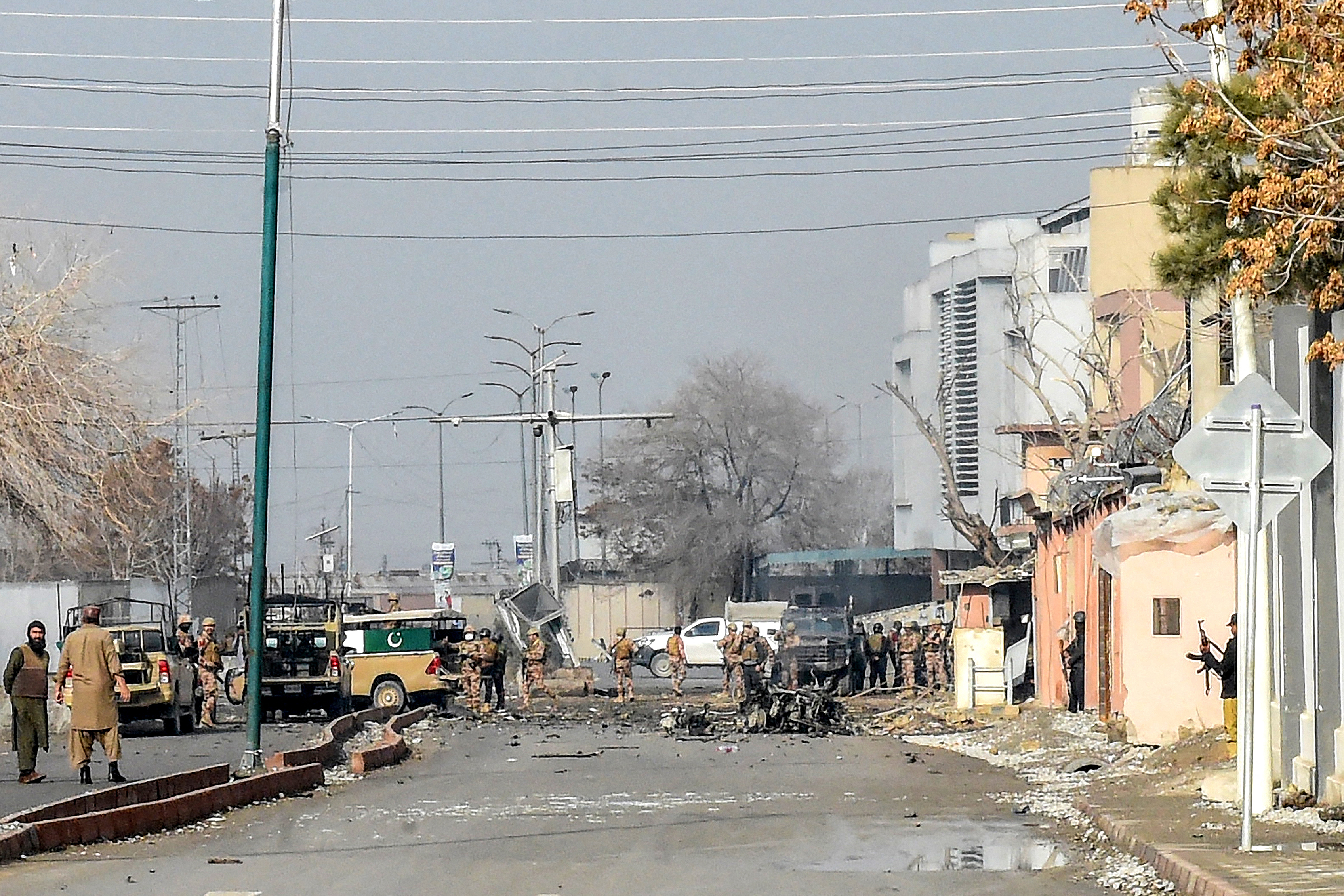 Security personnel inspect a blast site after an attack.