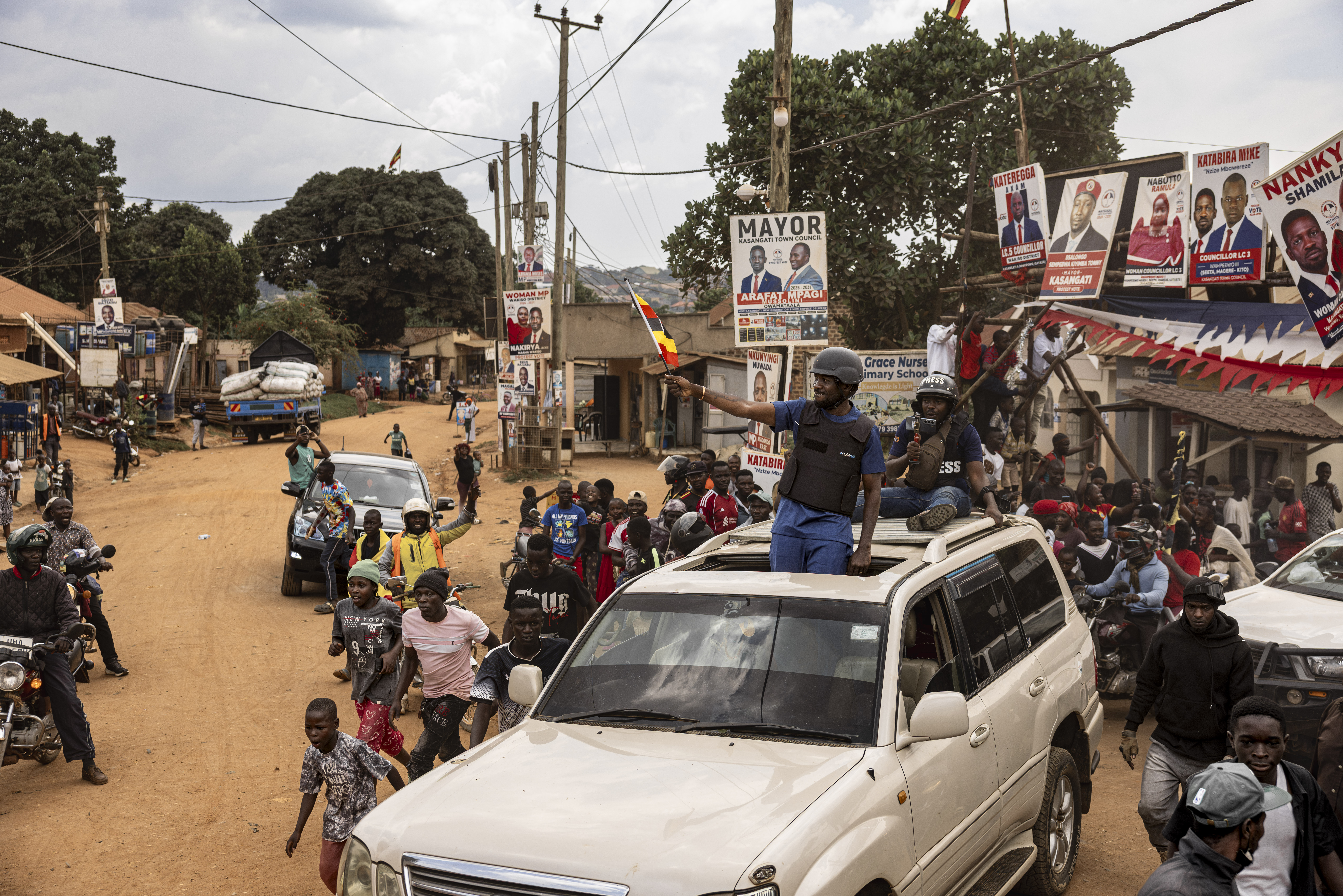 KAMPALA, UGANDA - JANUARY 13: Crowds of supporters gather outside the home of Bobi Wine as he prepares to depart for the National Unity Platform's final campaign rally ahead of Uganda's 2026 general elections > on January 13, 2026 in Kampala, Uganda. Robert Kyagulanyi Ssentamu, popularly known as Bobi Wine, is a Ugandan musician, activist, and politician currently serving as the president of the National Unity Platform (NUP). As of January 2026, he is the primary opposition candidate challenging incumbent President Yoweri Museveni in Uganda's upcoming general election to be held on January 15. (Photo by Michel Lunanga/Getty Images)