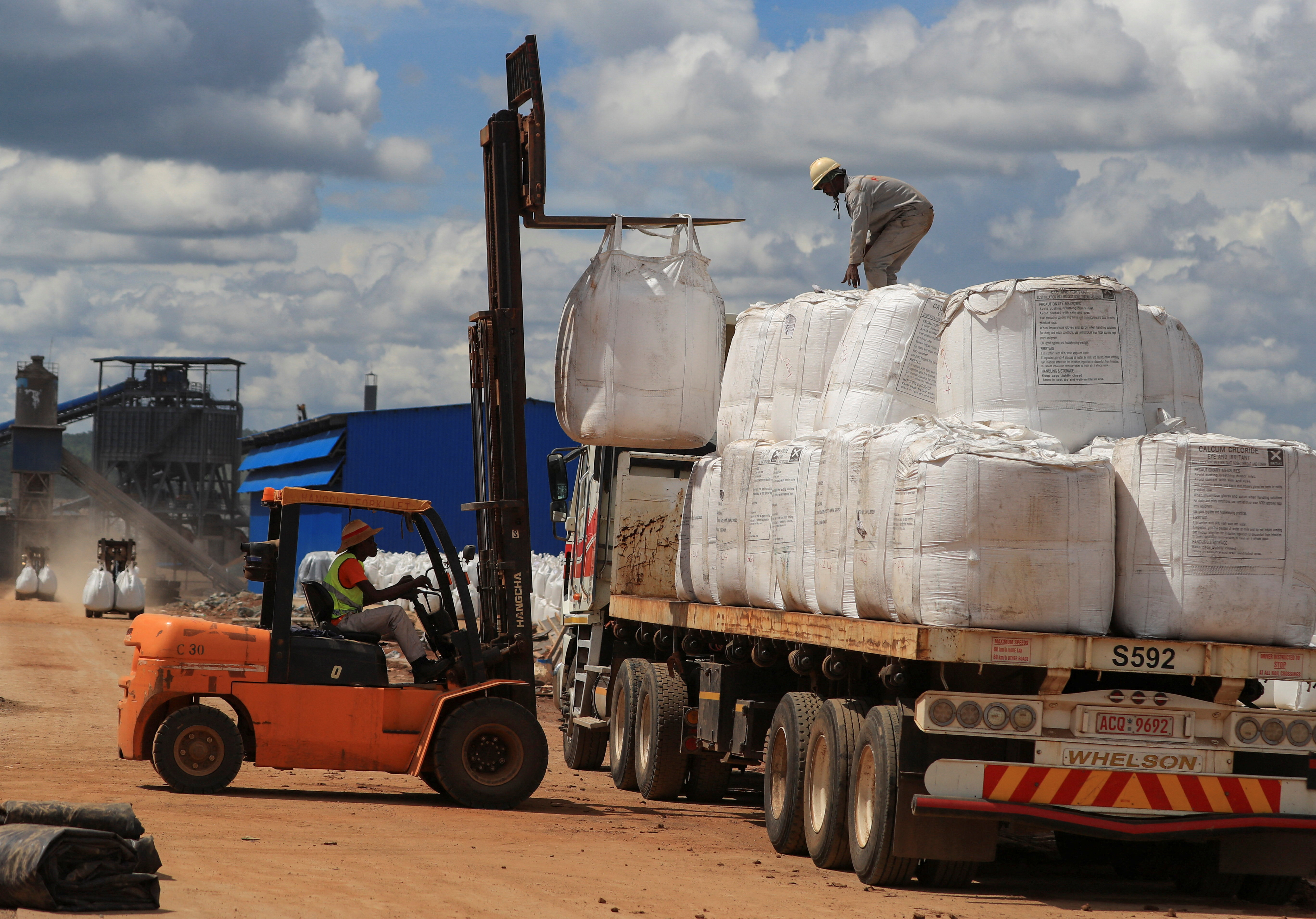 Workers load lithium concentrate at Prospect Lithium Zimbabwe mine in Goromonzi