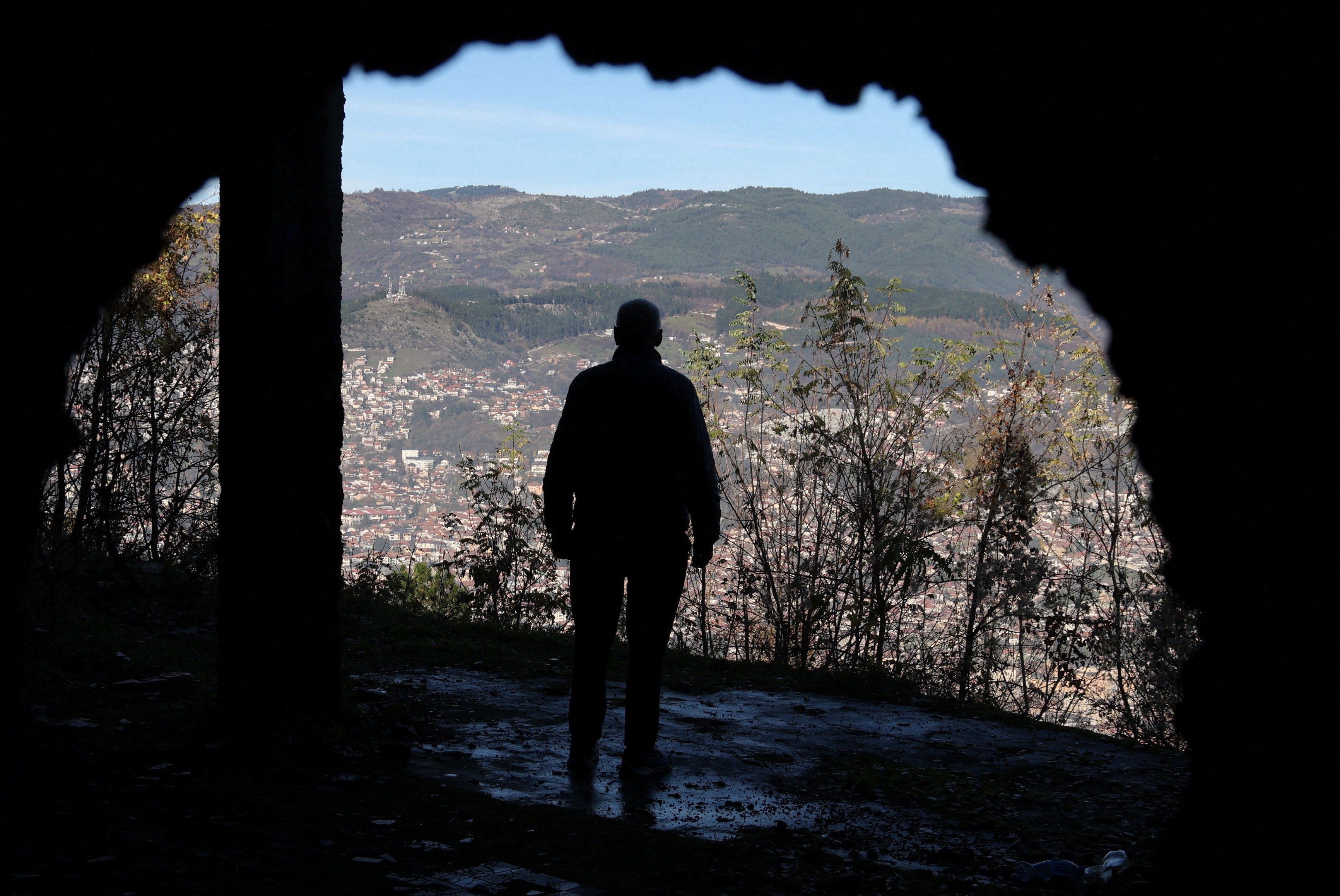 A Bosnian worker looks out at Sarajevo through a hole in a war-damaged building that once marked the front line during the 1992?95 Bosnian War, in Sarajevo, Bosnia and Herzegovina, November 13, 2025. REUTERS/Amel Emric