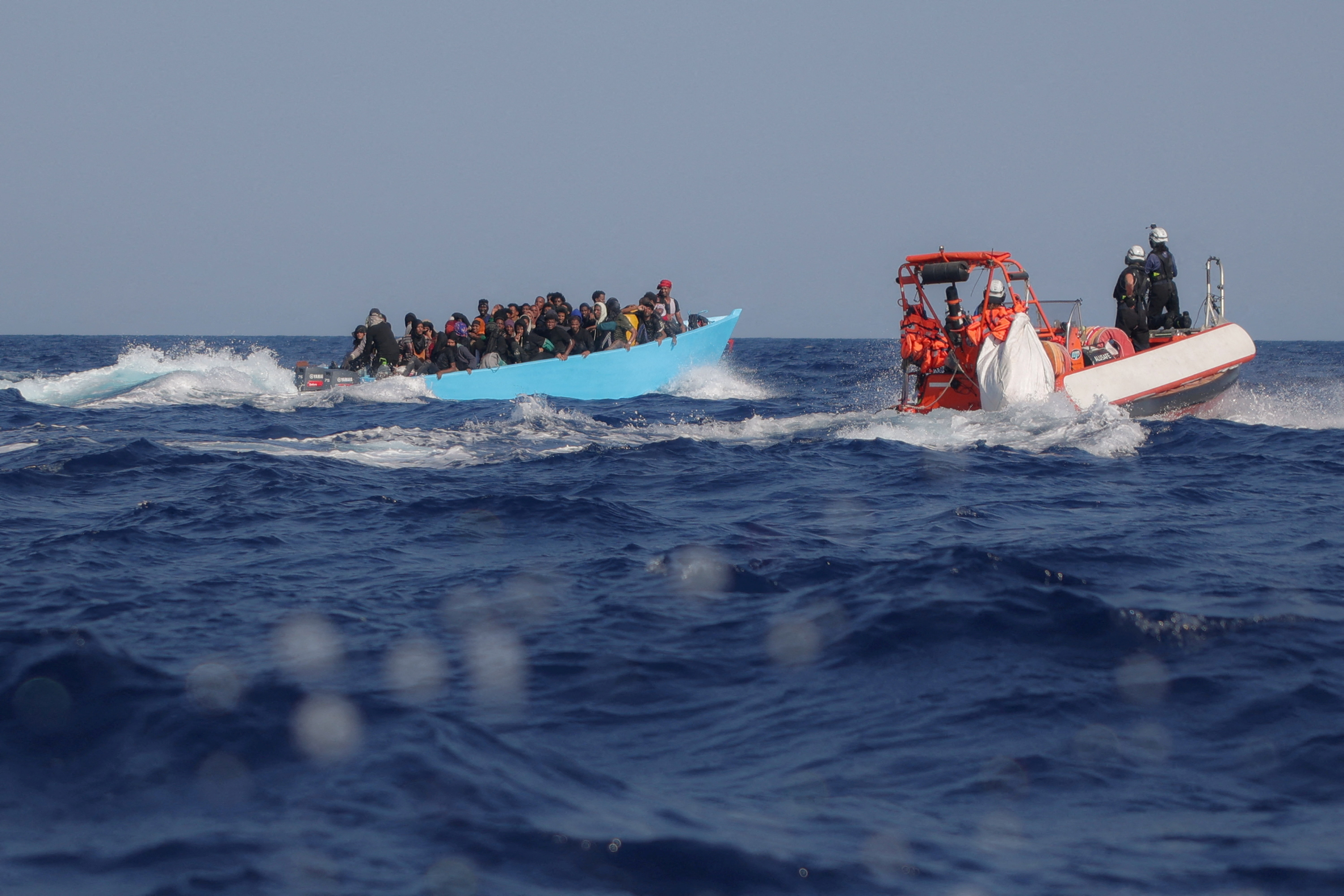 People on board an overcrowded boat are approached by the crew of the search and rescue ship Sea-Watch 5 in the central Mediterranean, off Libya