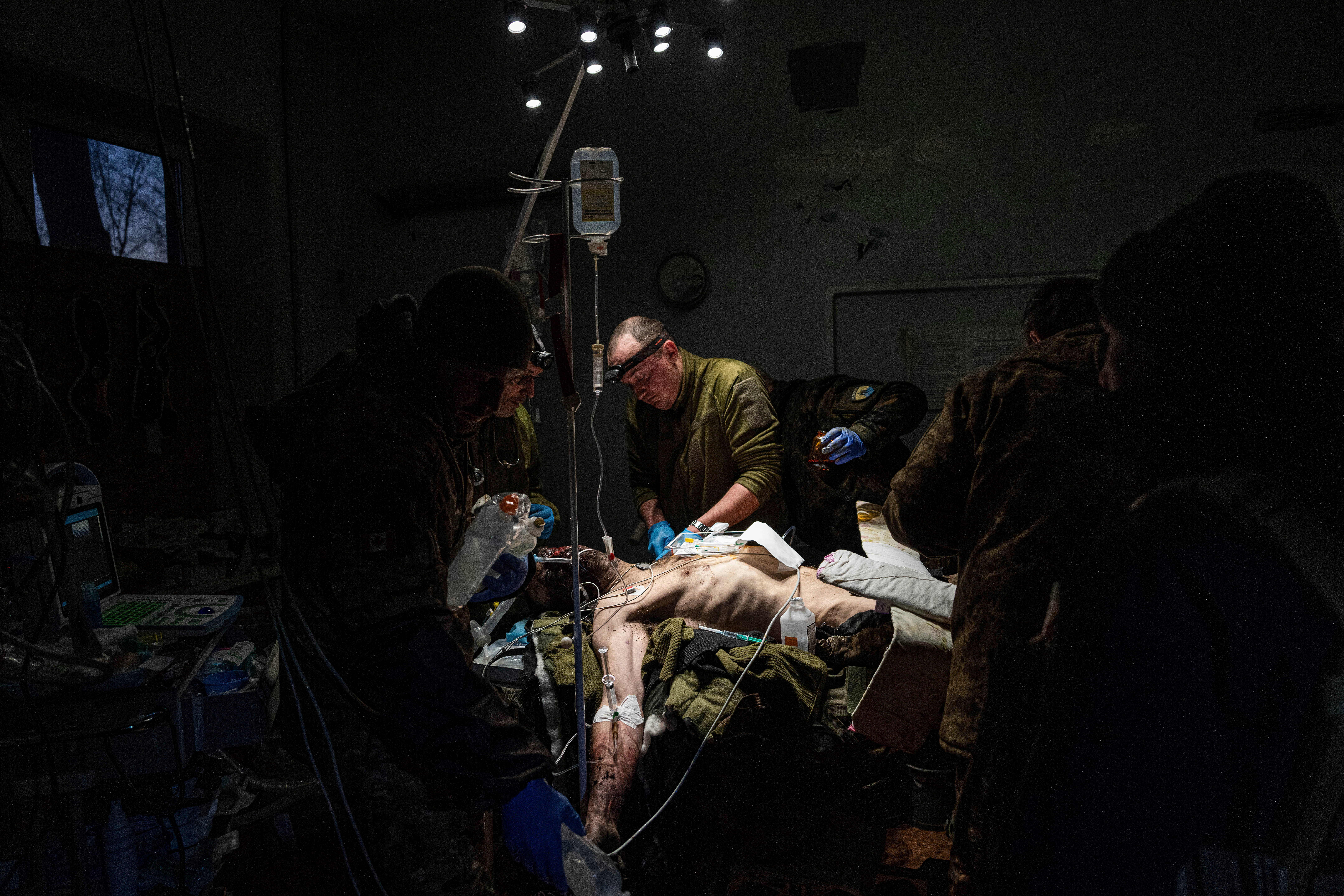 Ukrainian military doctors treat an injured comrade who was evacuated from the battlefield in a hospital in the Donetsk region