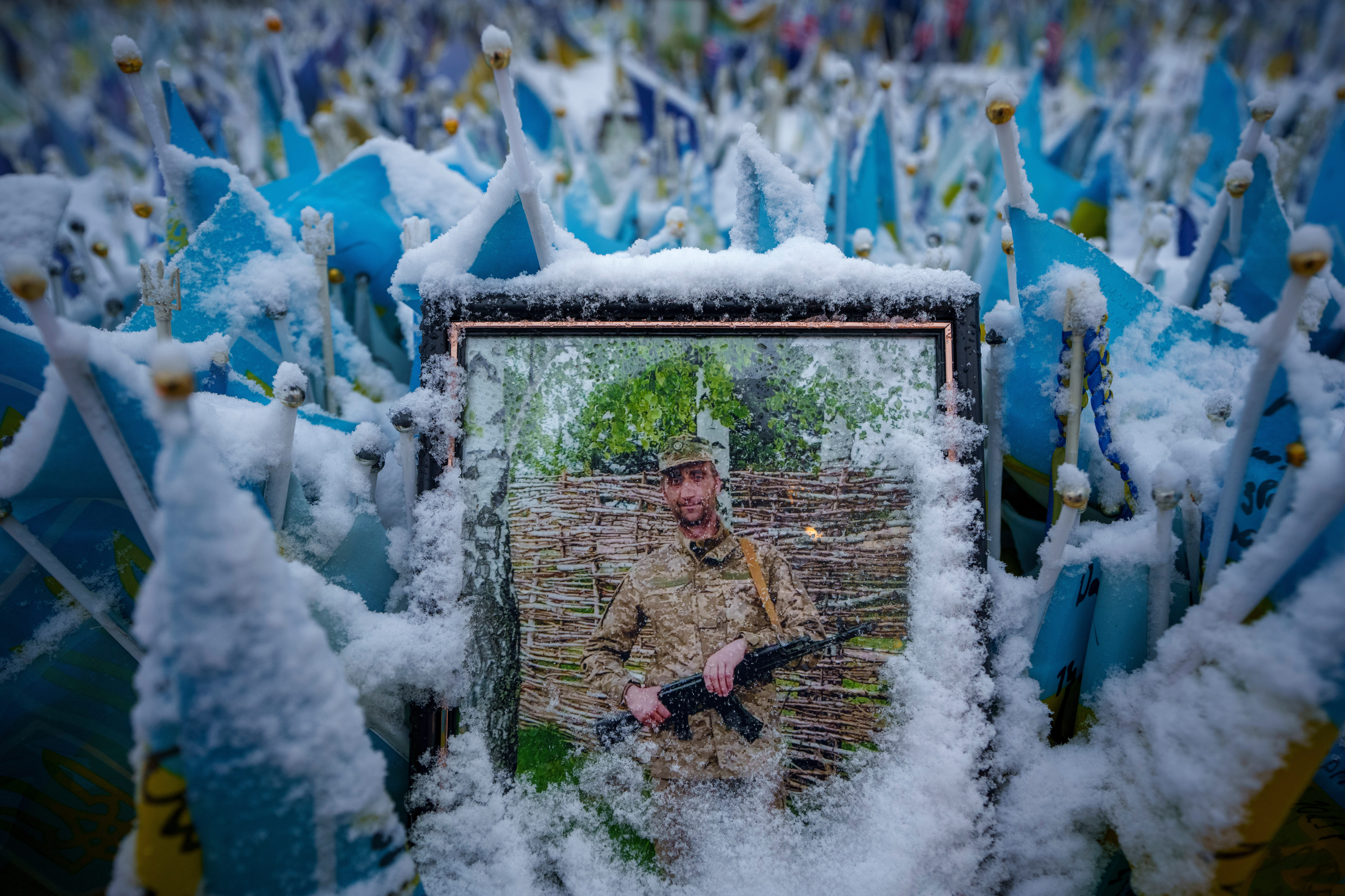 Snow covers the photograph of a fallen Ukrainian serviceman in downtown Kyiv, Ukraine