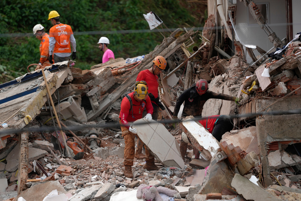 rescue workers look through debris following a flood