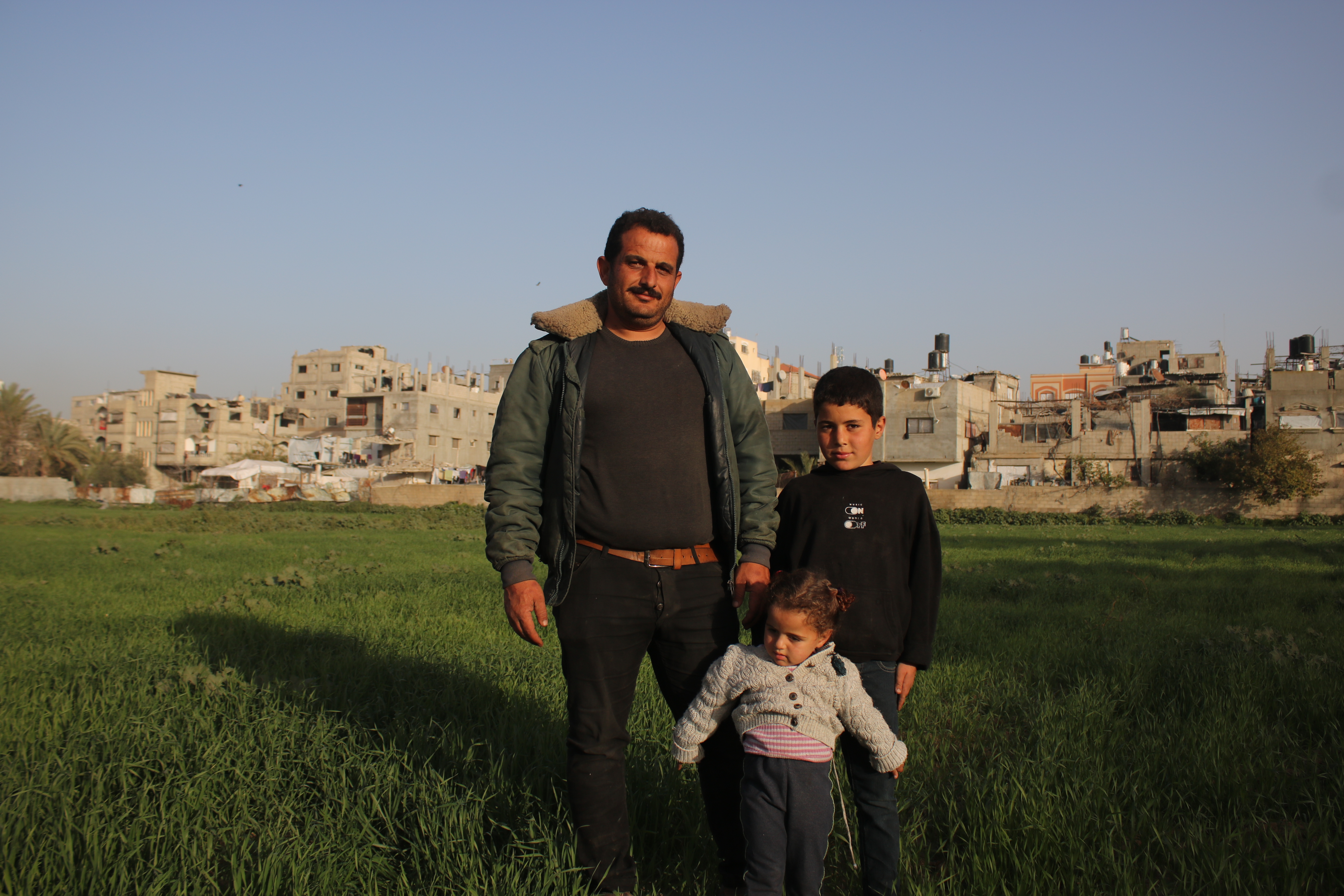 Mohammed al-Slakhy and his two children in a field