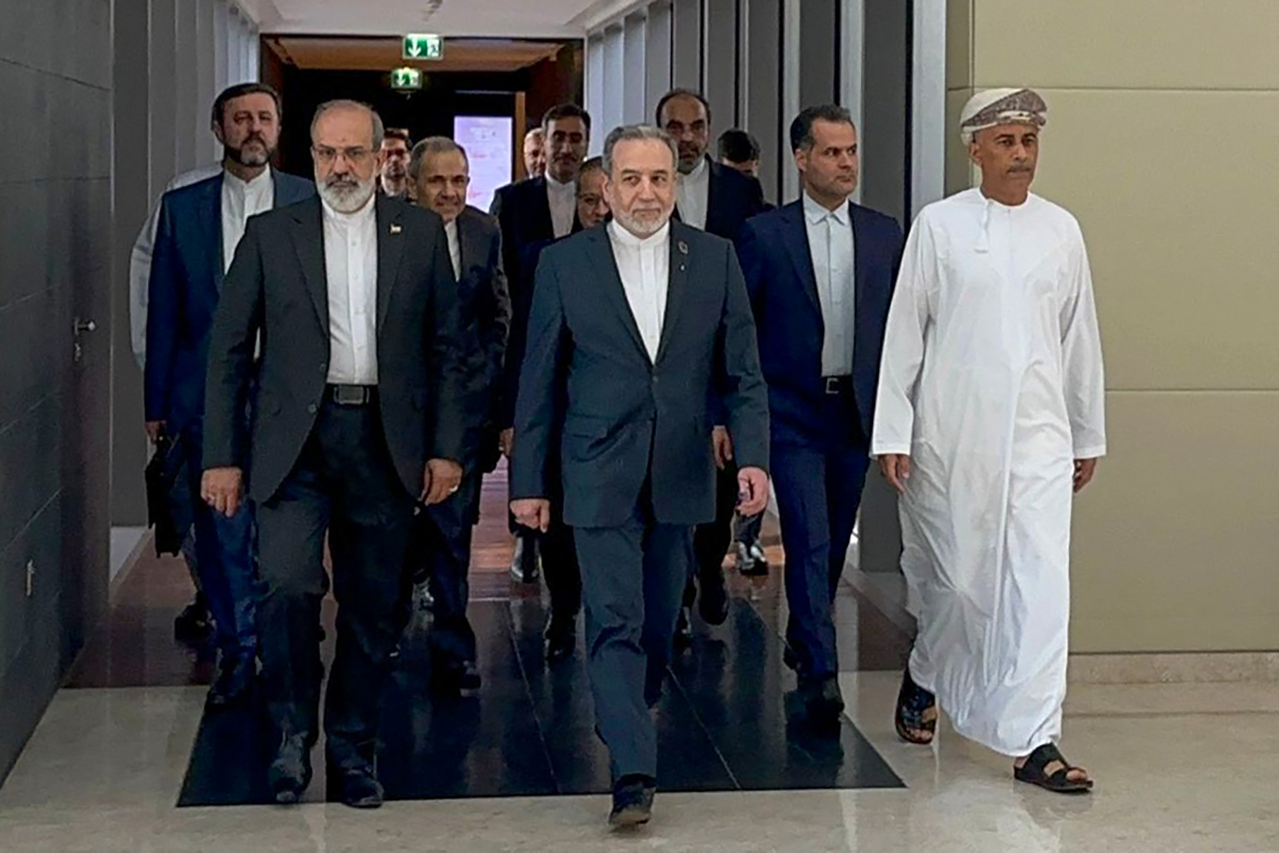 In this handout photo obtained from Iran’s foreign ministry delegation on February 6, 2026, Iran’s Foreign Minister Abbas Araghchi (C) arrives for a meeting in Muscat.