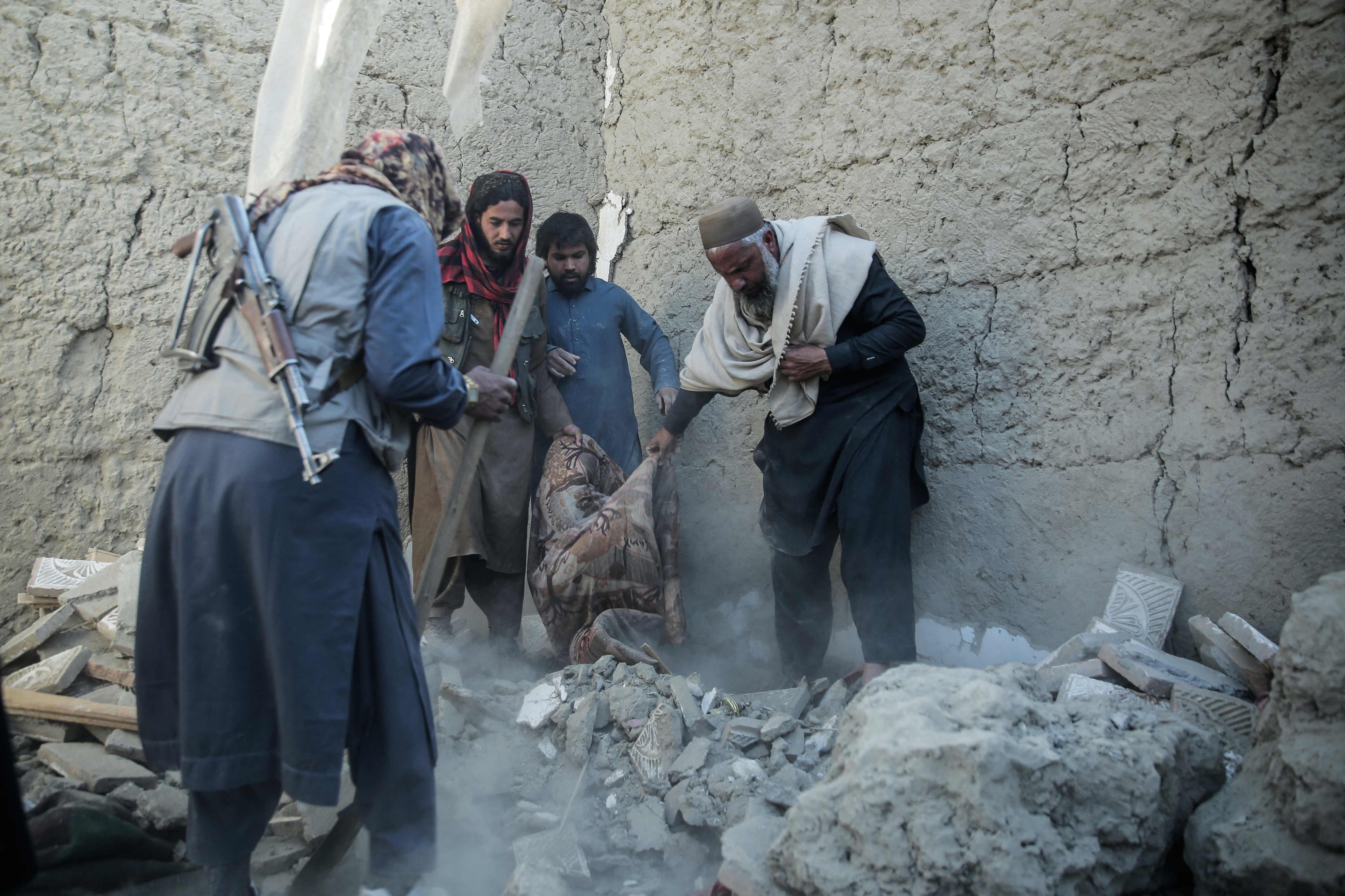 Taliban security personnel and residents search for victims after an overnight Pakistani air strike hit a residential area at the Girdi Kas village in Bihsud district, Nangarhar province on February 22, 2026.
