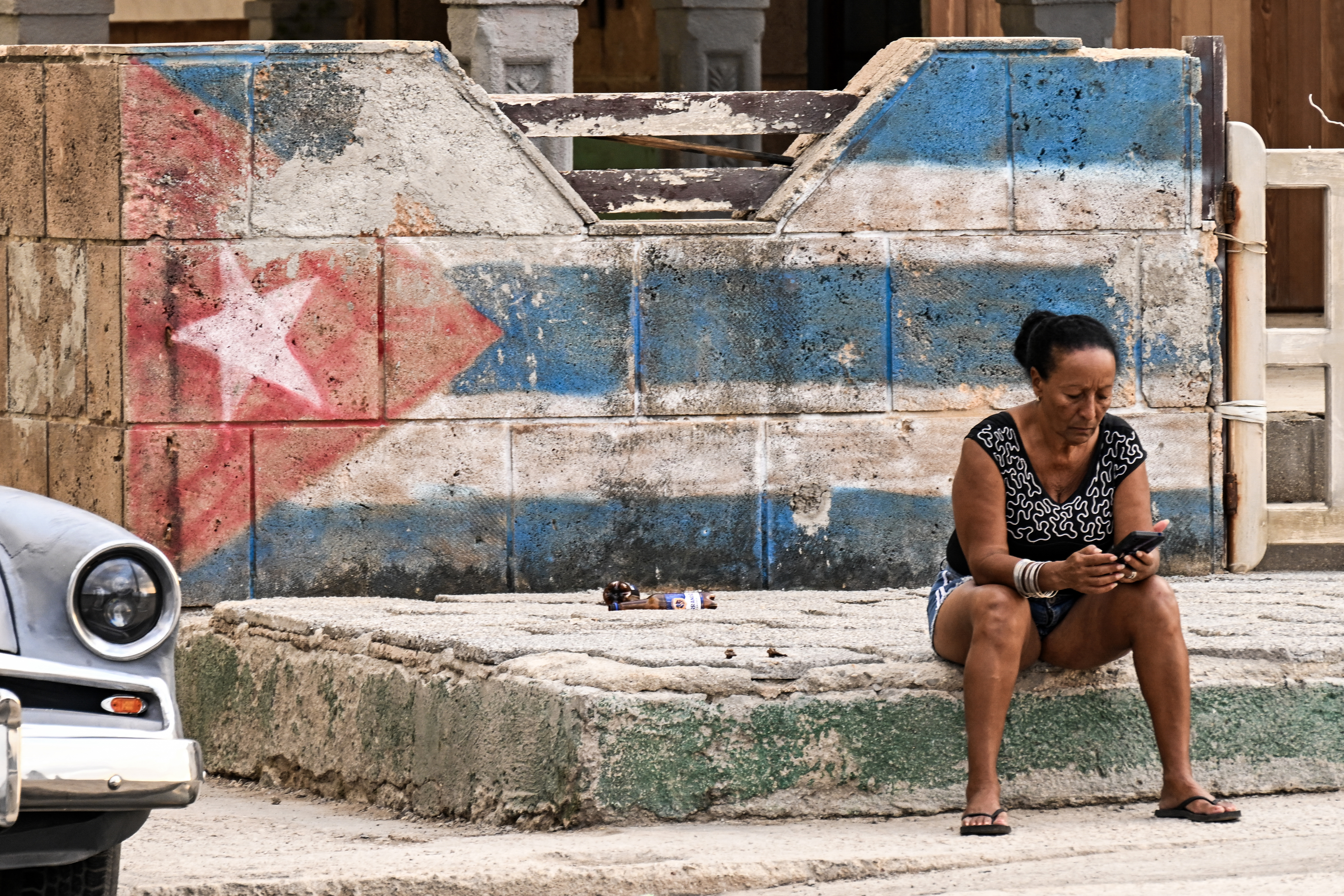 A woman looks at her cellphone on a street in Havana on February 23, 2026.