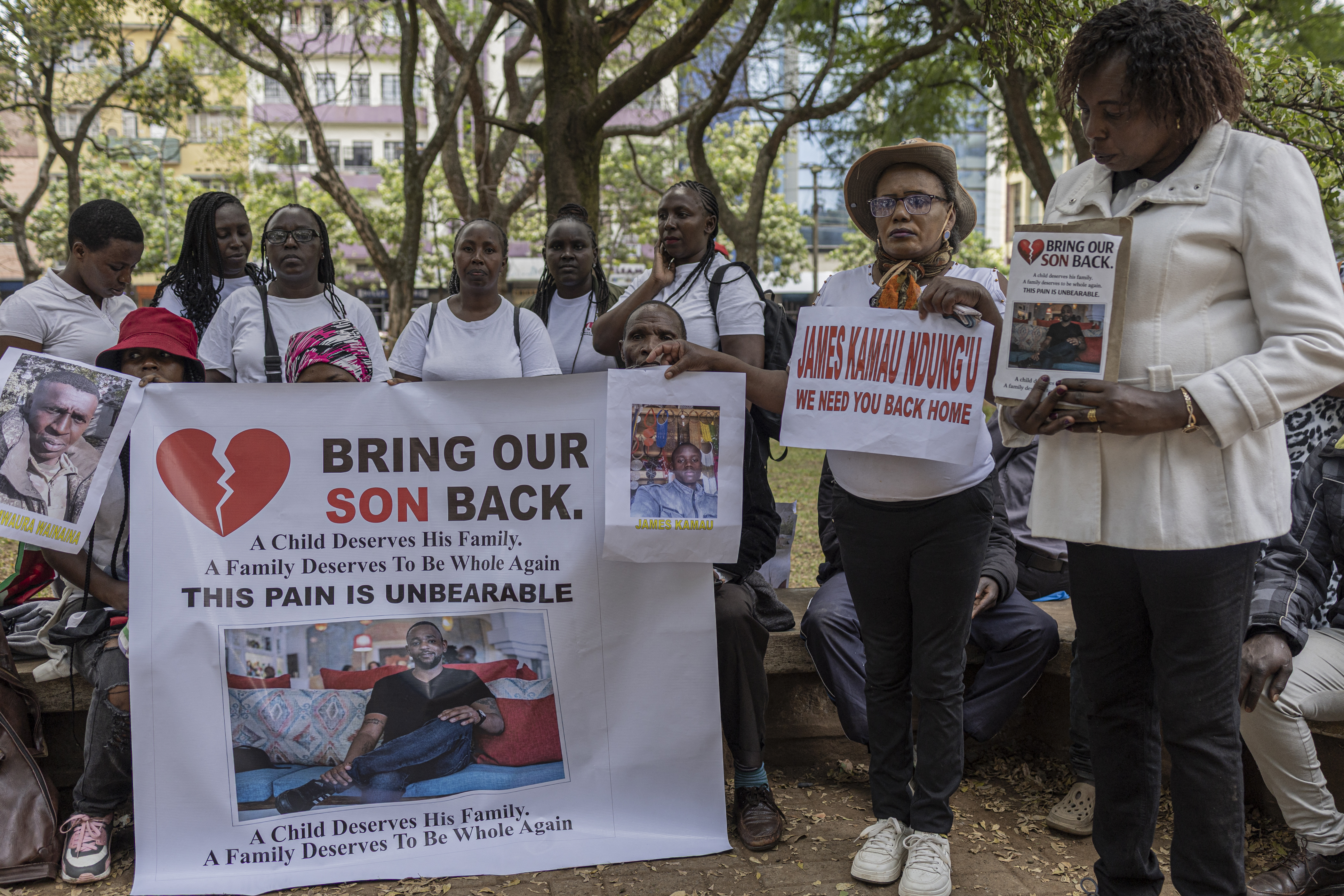 Relatives of Kenyan nationals conscripted by the Russian army in Ukraine pose with photos of their family members during a prayer and peaceful demonstration.