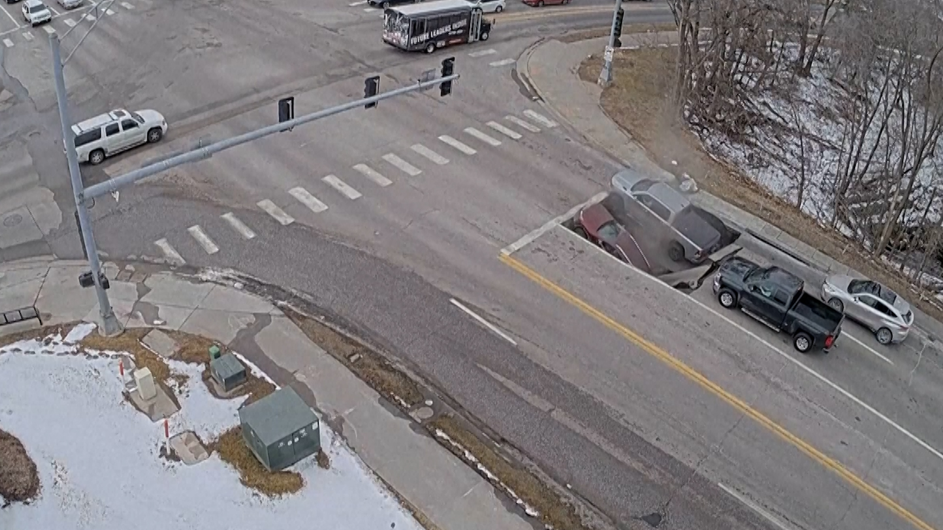 A screenshot shows two cars being swallowed by a gigantic sinkhole in Omaha, Nebraska, US on Feb. 24, 2026. [UNO Public Safety/TMX via AP]