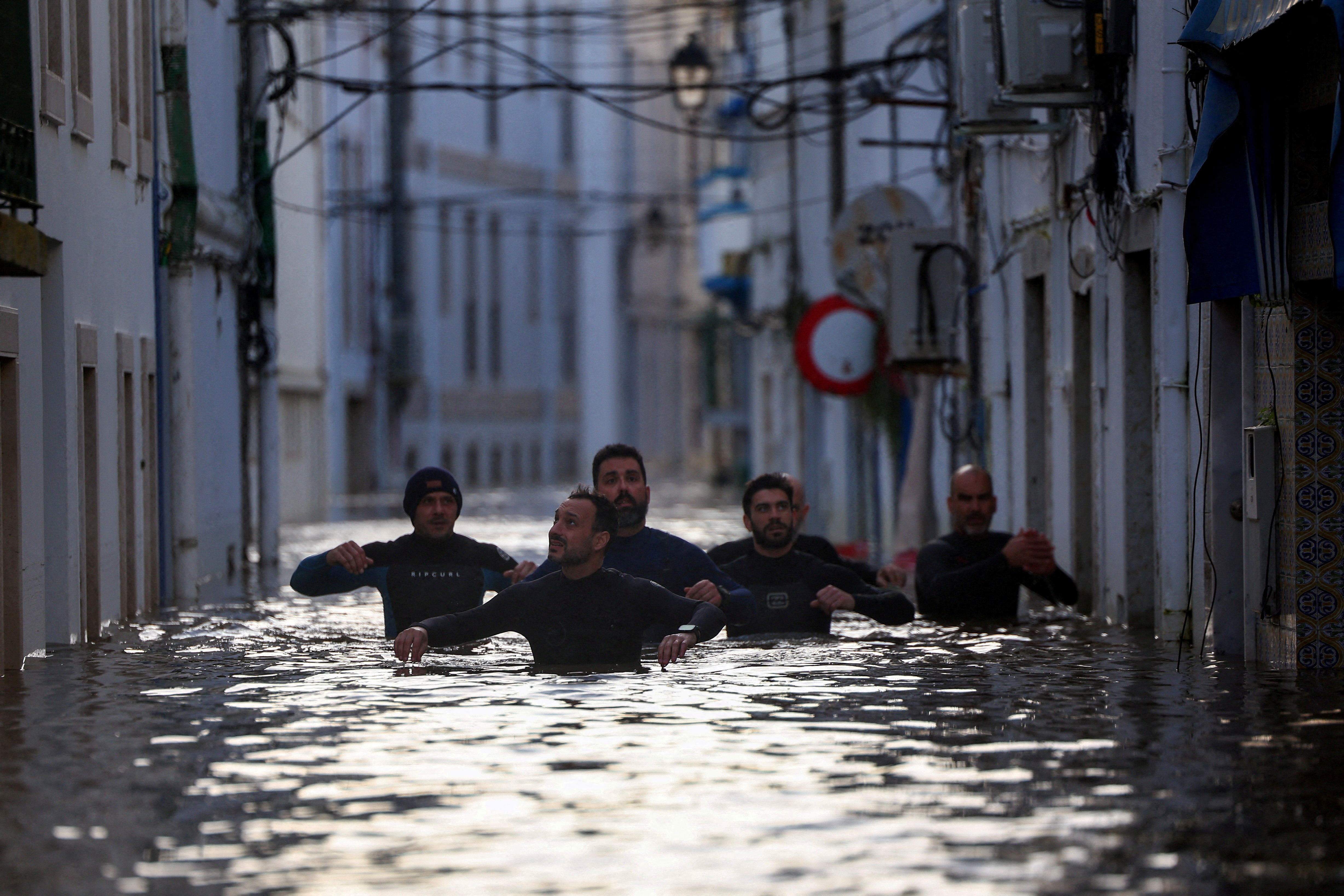 Volunteers wade through a flooded street after Storm Leonardo passed by Alcacer do Sal, Portugal, February 5, 2026. REUTERS/Pedro Nunes TPX IMAGES OF THE DAY
