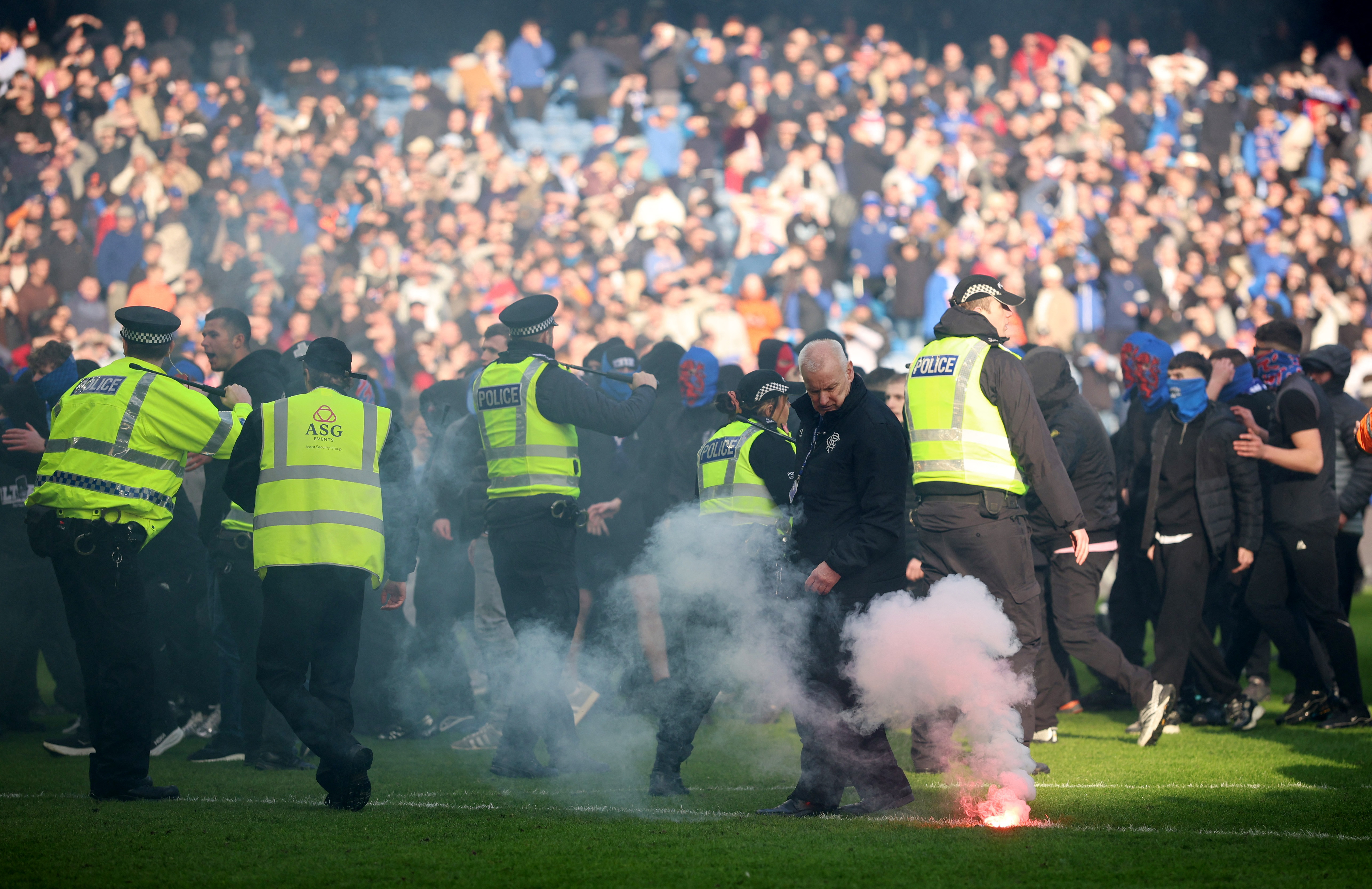 Soccer Football - Scottish League Cup - Quarter Final - Rangers v Celtic - Ibrox, Glasgow, Scotland, Britain - March 8, 2026 General view of a flare on the pitch as Rangers fans clash with police after the match Action Images via REUTERS/Lee Smith