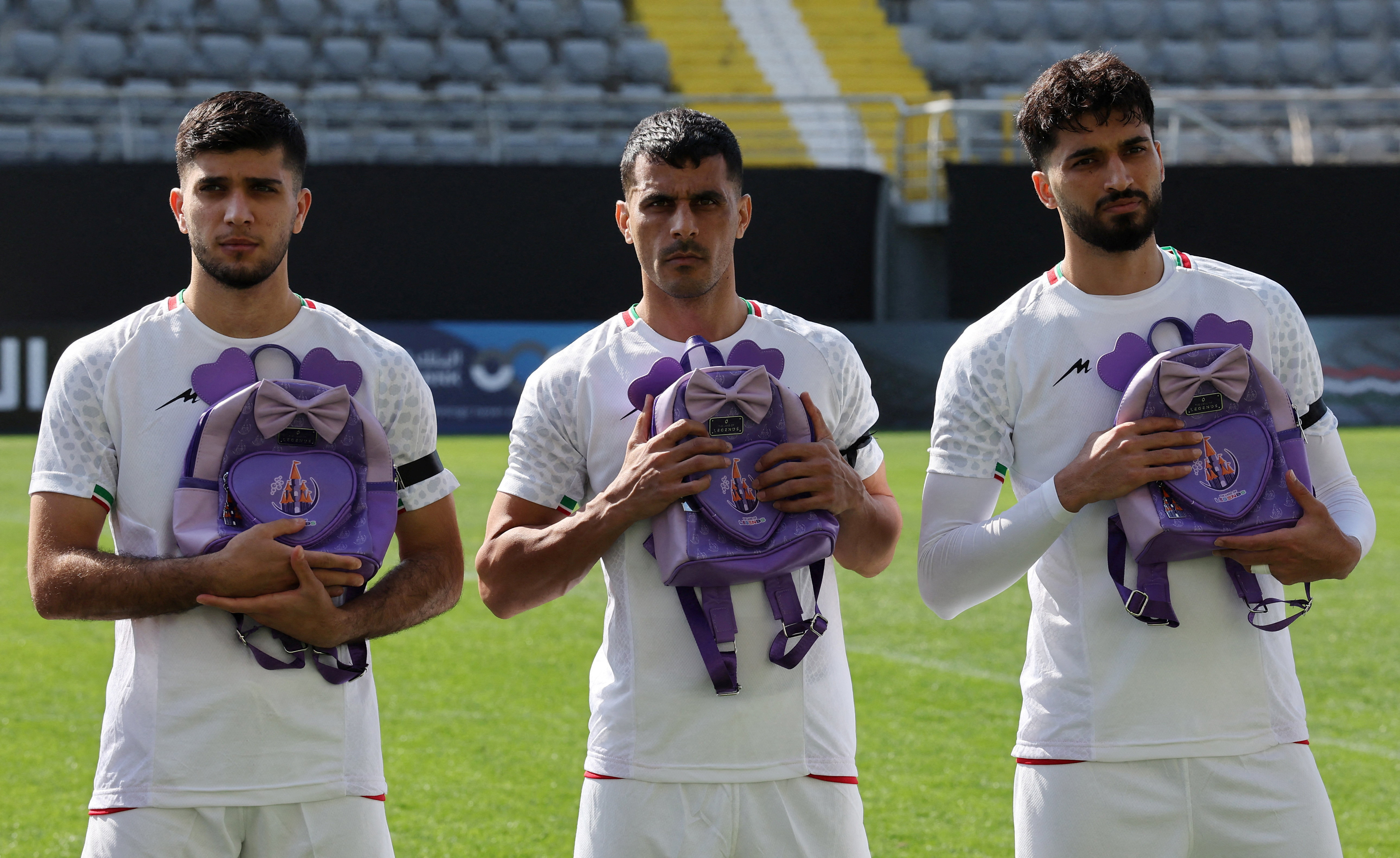 Iran's Aria Yousefi, Ali Nemati and Mohammad Ghorbani hold school bags in memory of the victims of the girls school bombing in Minab, Iran