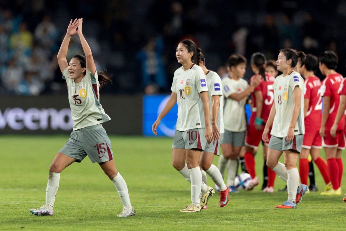 China's Wang Aifang (L) celebrates with teammates on the pitch.
