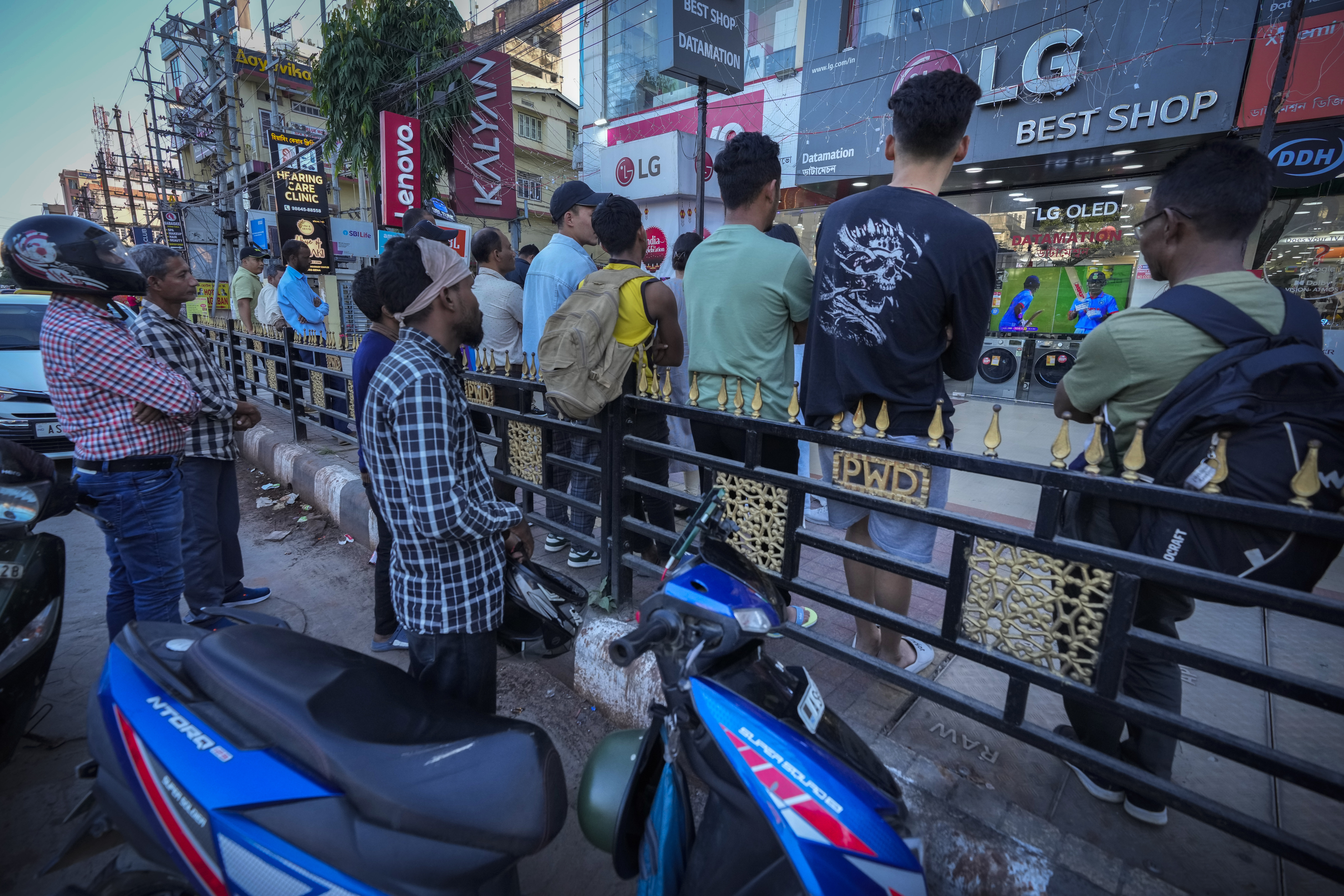 Indians watch the live telecast of ICC Men's Cricket World Cup final match between Australia and India on a television displayed at a TV store in Guwahati, India, Sunday, Nov. 19, 2023. (AP Photo/Anupam Nath)