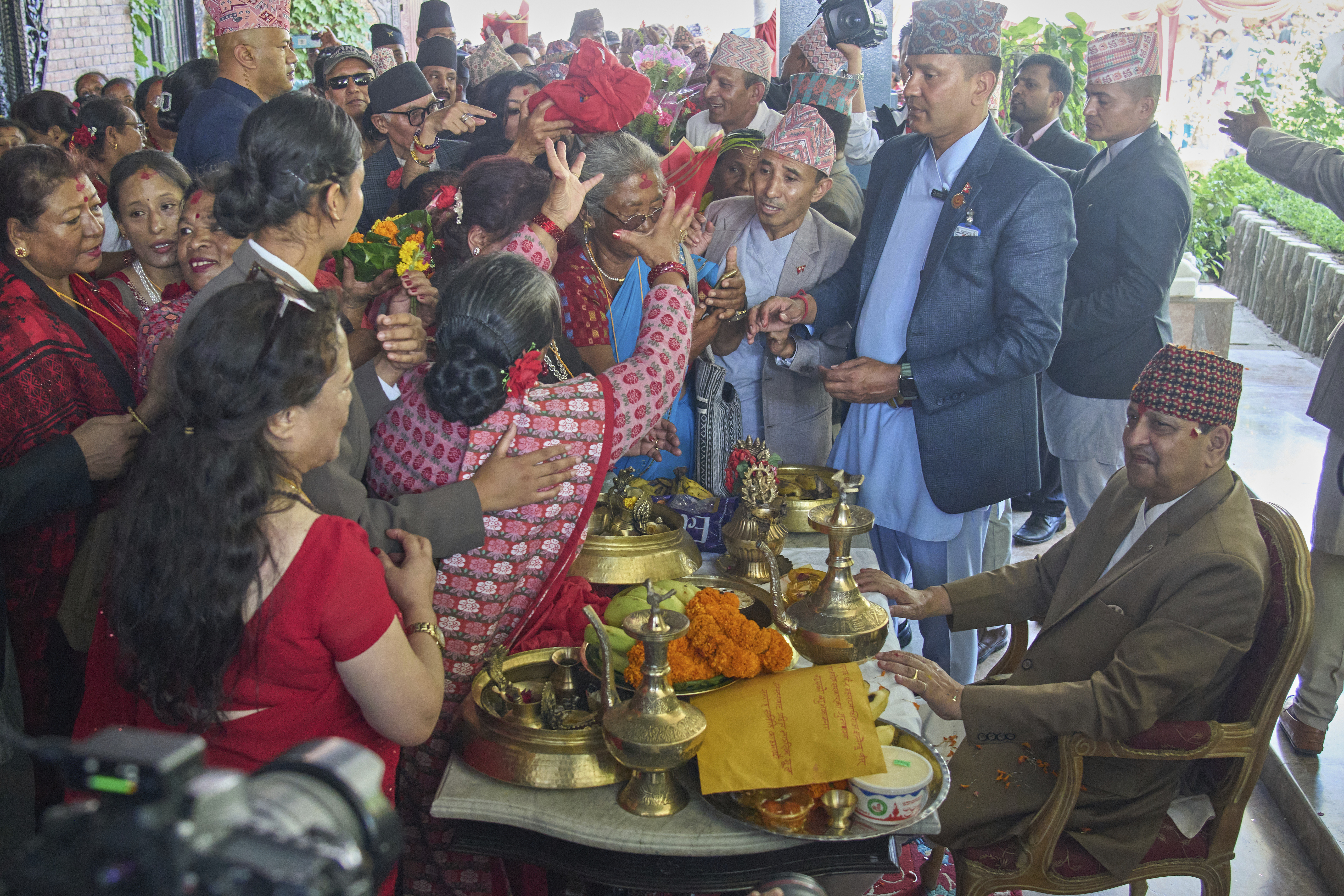 Supporters perform birthday rituals for former King Gyanendra Shah, sitting at right, at his residence in Kathmandu, Nepal, Monday, July 7, 2025. (AP Photo/Niranjan Shrestha)